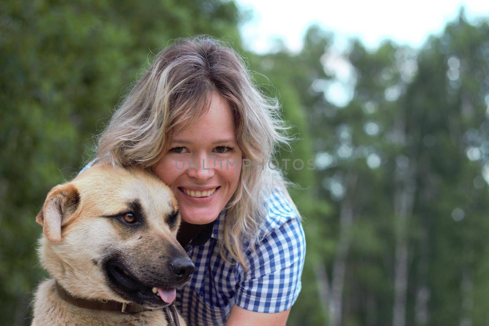 Beautiful yong woman is cuddling cute dog in the farm expressing animal love like a friend, this dog is domesticated to help and share in human life.