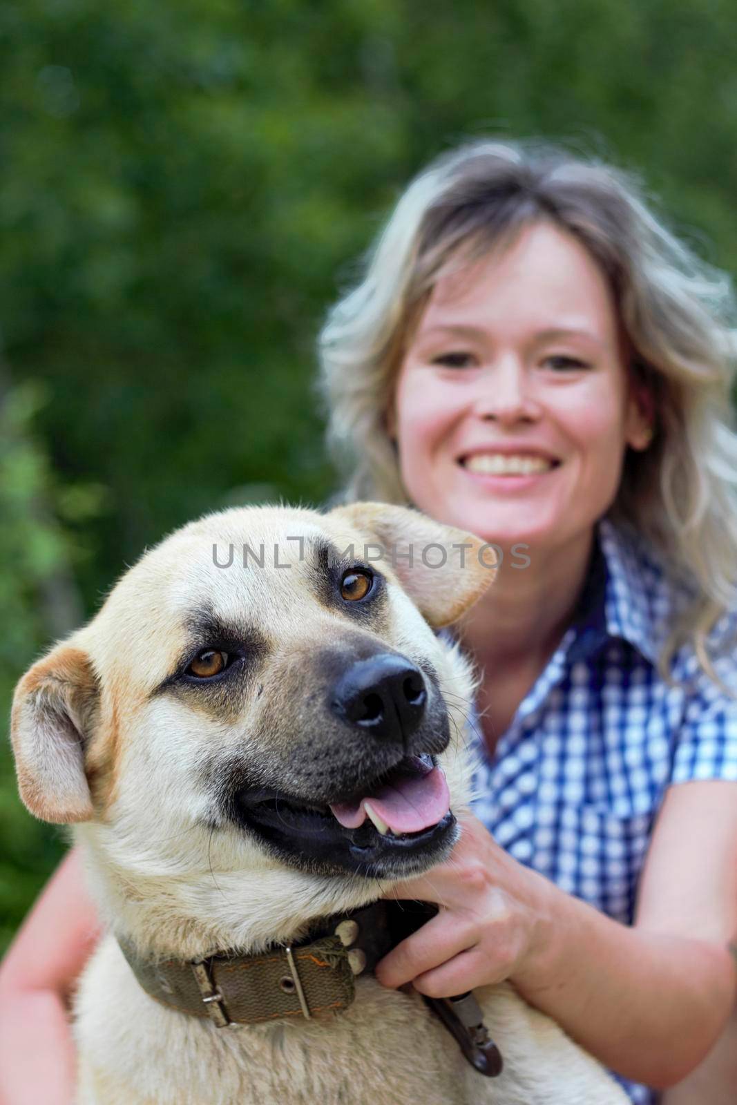 Beautiful yong woman is cuddling cute dog in the farm expressing animal love like a friend, this dog is domesticated to help and share in human life.