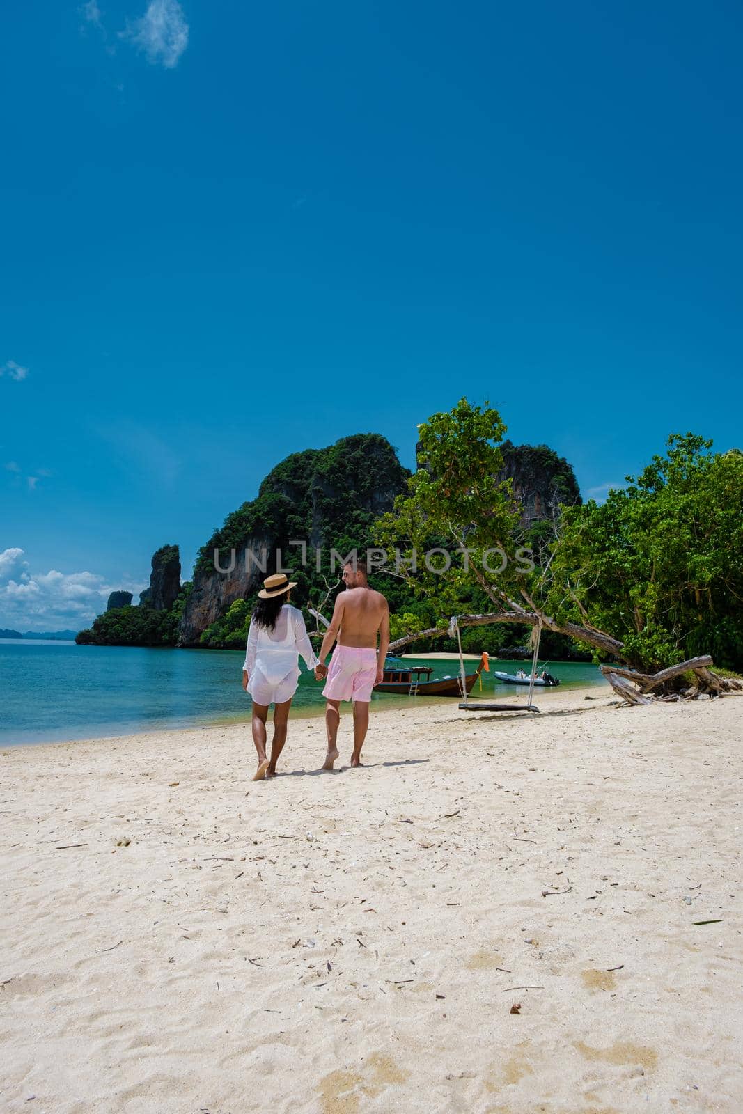 Koh Phakbia Island is near Koh Hong Krabi, a beautiful white sandy beach in Krabi Thailand. Young Asian woman and European men on the beach.