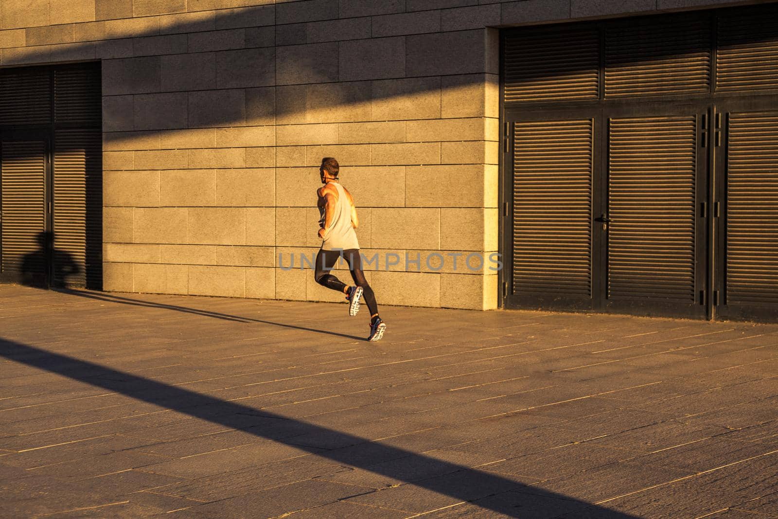 Aged sportsman running on country road, healthy inspirational fitness lifestyle, sport motivation speed interval training. Runner jogging training and doing workout exercising power walking outdoors in city.