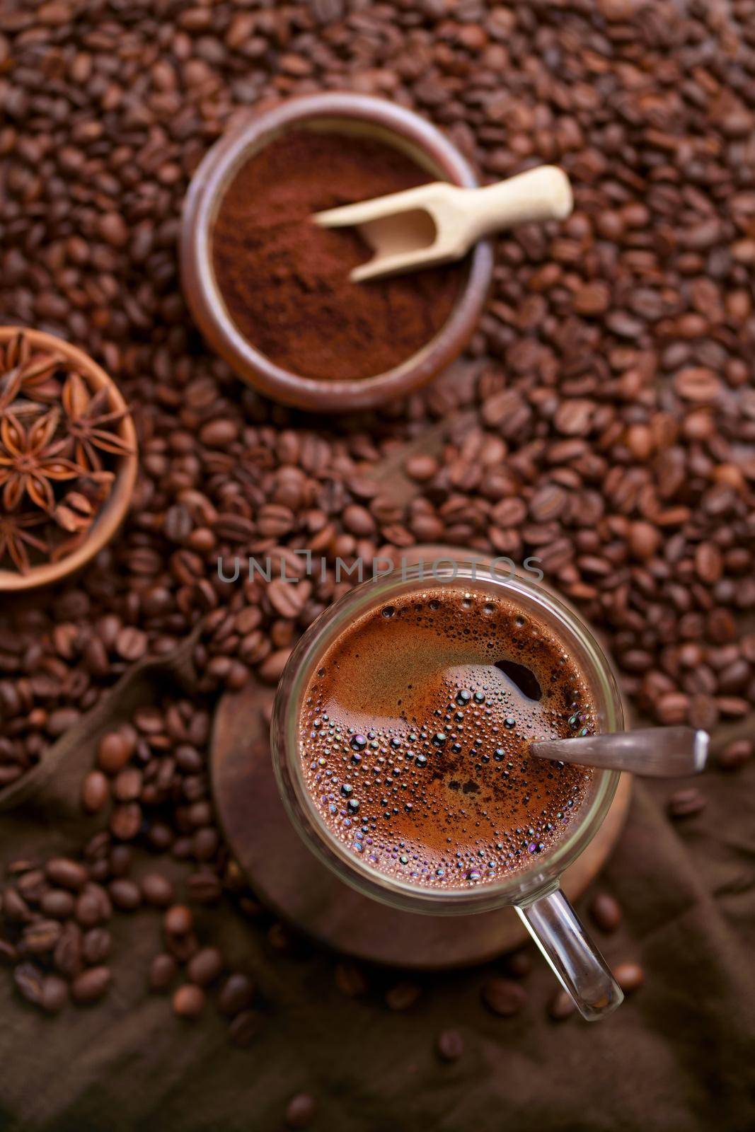 Hot black coffee and coffee beans on the old wooden table