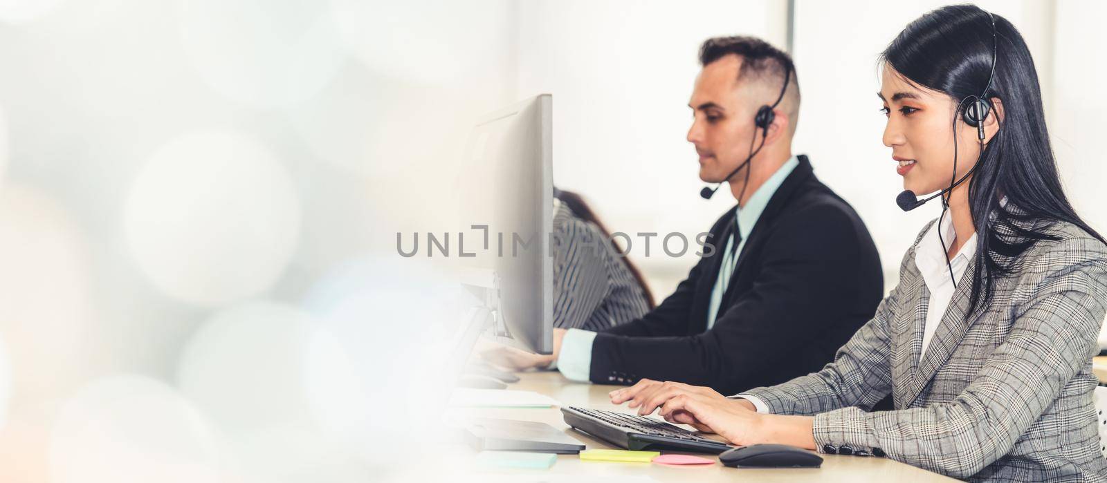 Business people wearing headset working in office to support remote customer or colleague. Call center, telemarketing, customer support agent provide service in broaden view .