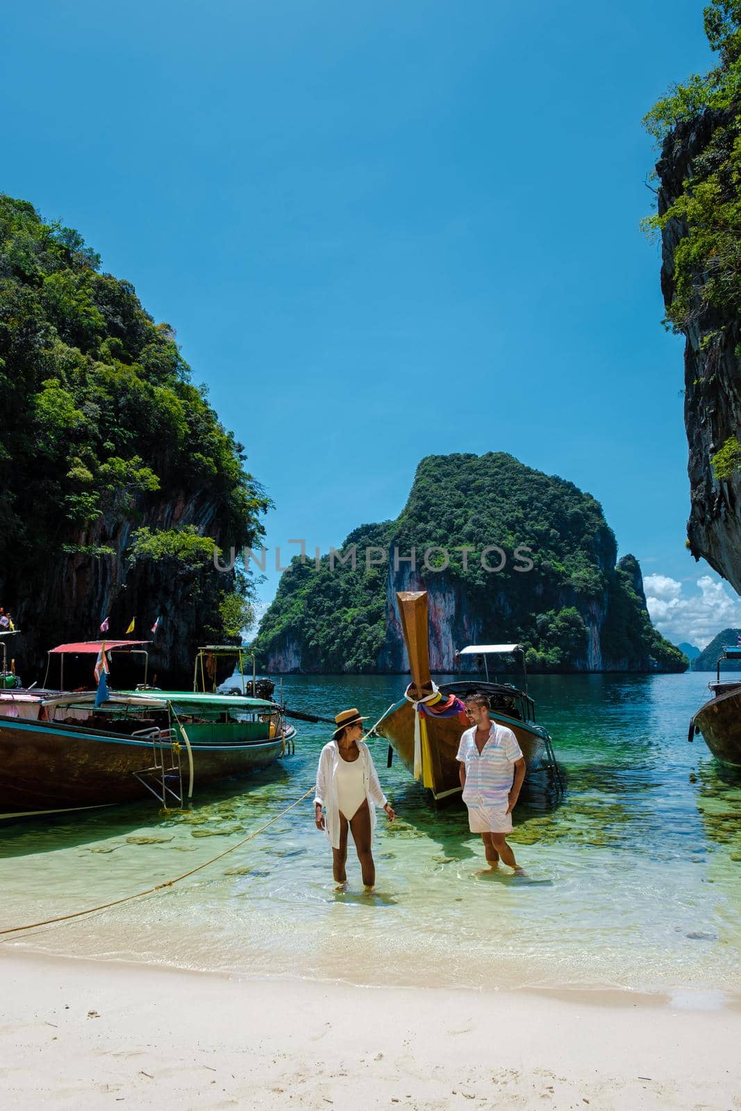 Koh Lao Lading near Koh Hong Krabi Thailand, beautiful beach with longtail boats, couple European men and Asian woman on the beach by fokkebok