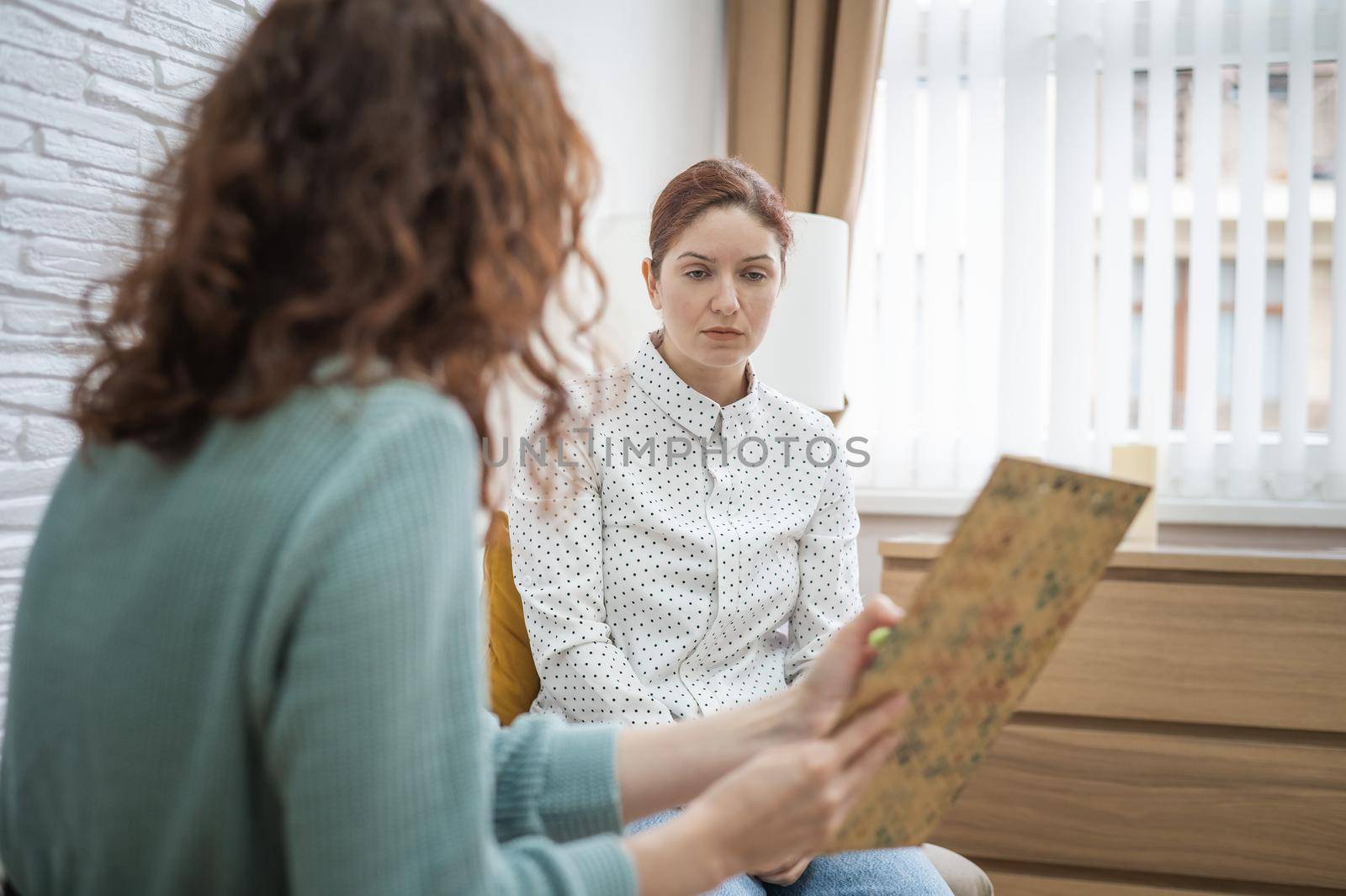Worried caucasian woman at a session with a psychotherapist. by mrwed54