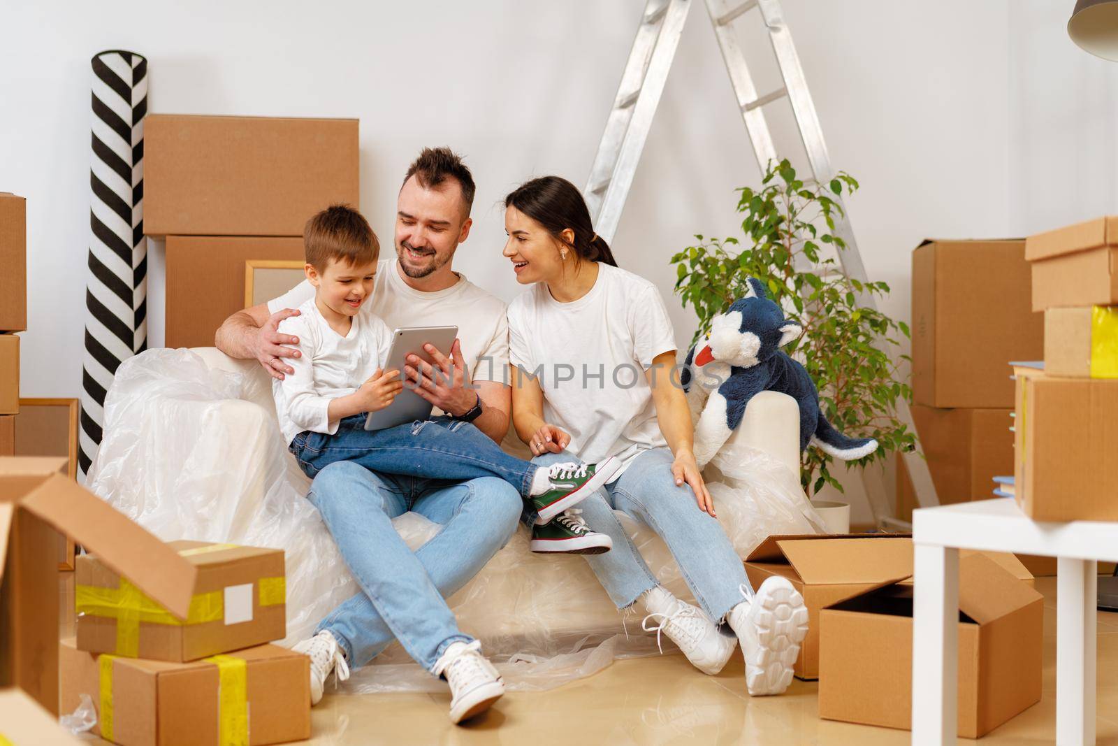Portrait of happy family with cardboard boxes in new house at moving day, close up