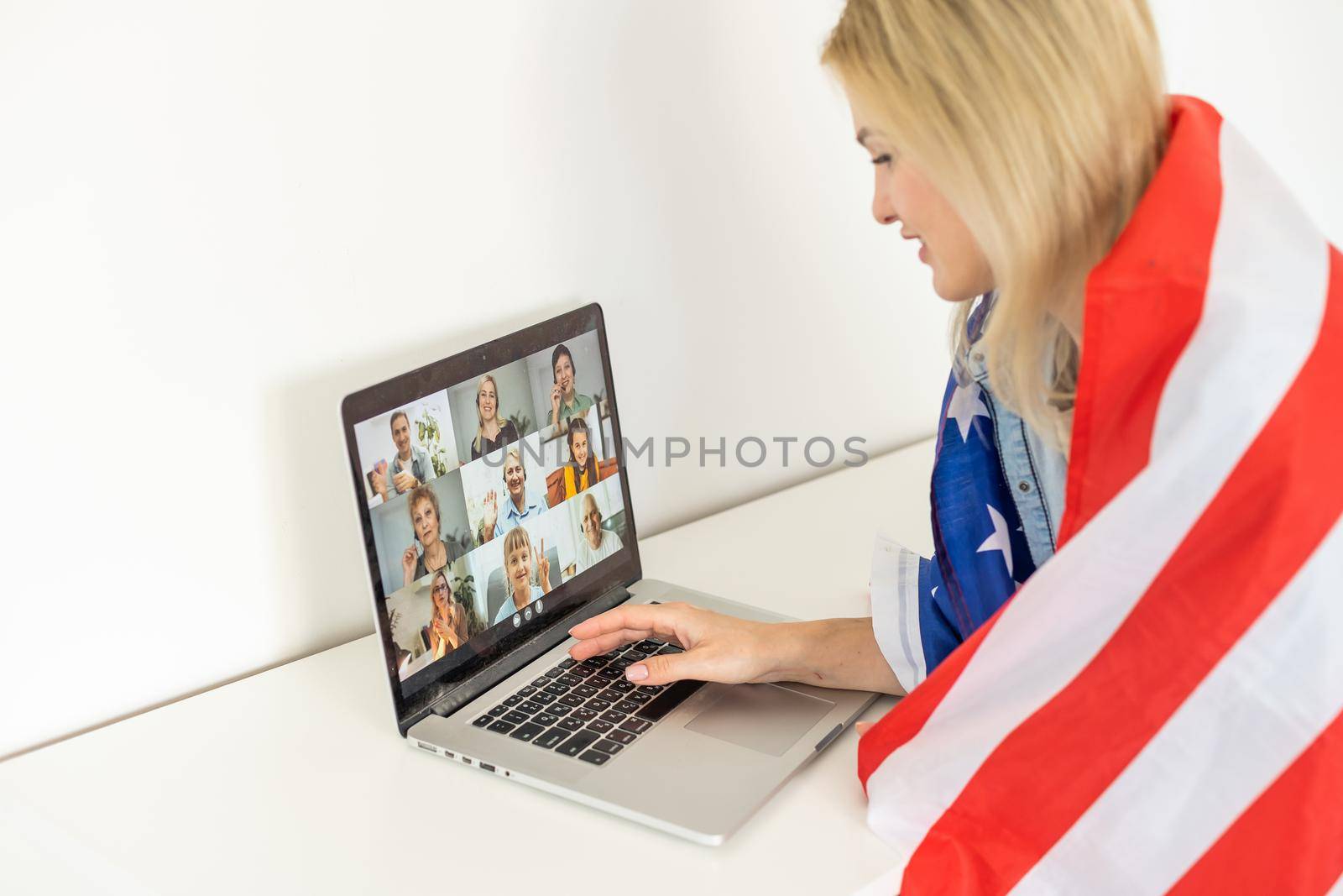 woman holding usa flag and video by laptop by Andelov13