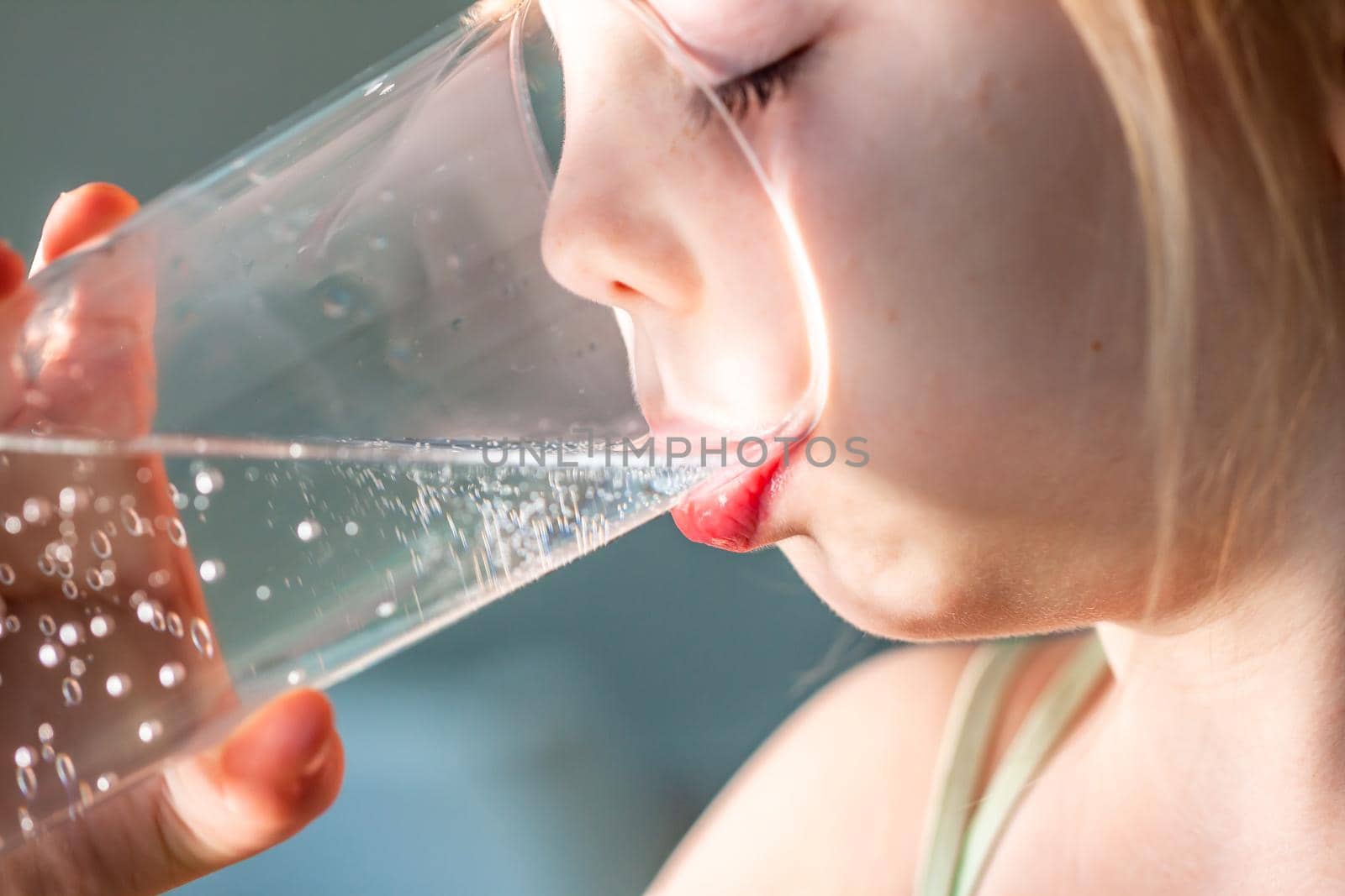 Little girl drinking a fresh glass of water.