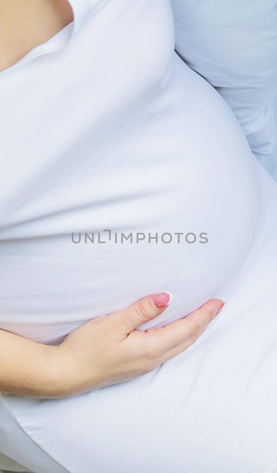 A pregnant woman hugs her belly. Selective focus. by yanadjana