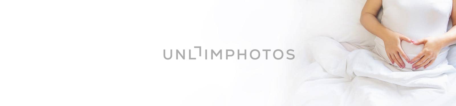 A pregnant woman hugs her belly. Selective focus. People.