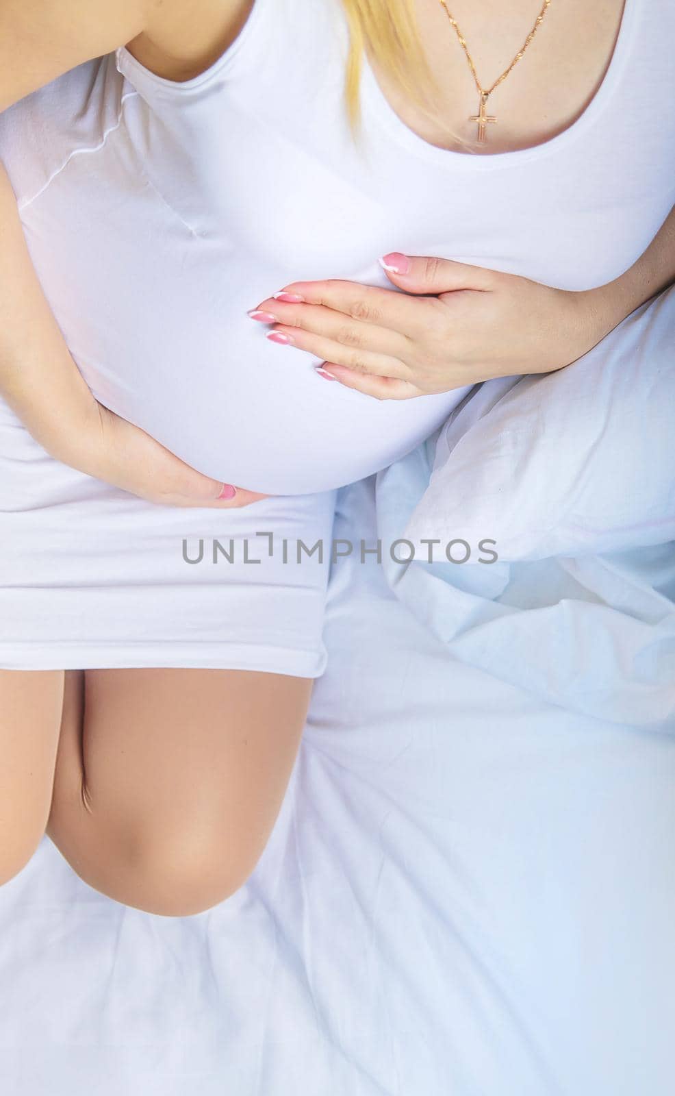 A pregnant woman hugs her belly. Selective focus. People.