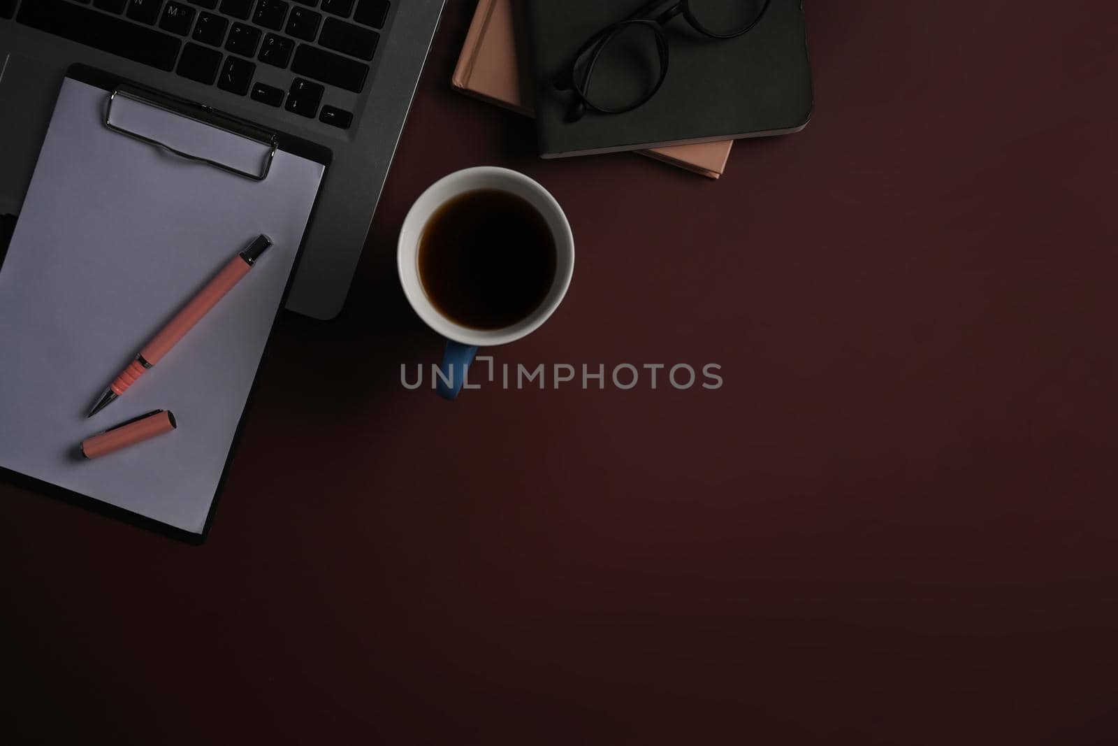Cup of coffee, notepad and computer laptop on purple background. by prathanchorruangsak