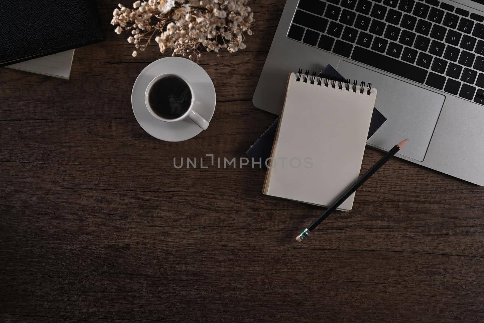 Blank notepad, laptop computer, coffee cup and flower pot on wooden desk. Flat lay, Top view by prathanchorruangsak