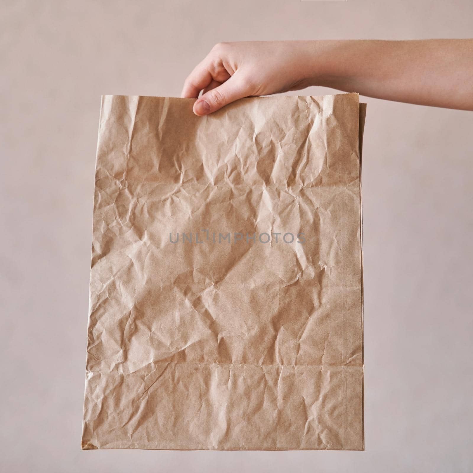 Girl holds an eco-friendly paper bag. Close-up. Shopping bag