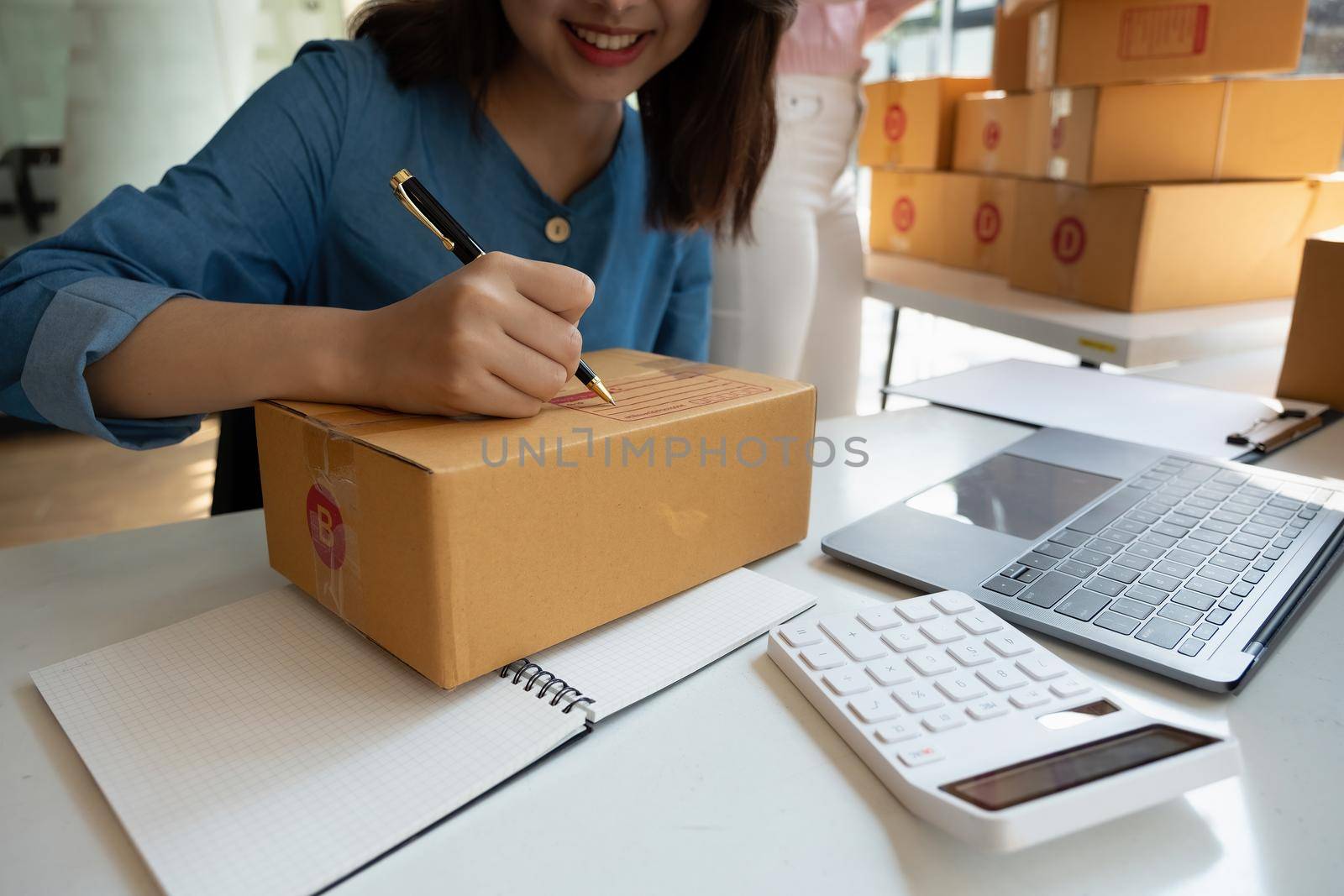 Close up hand of young woman small business owner online shopping at home preparing package product on background. SME entrepreneur or freelance life style concept