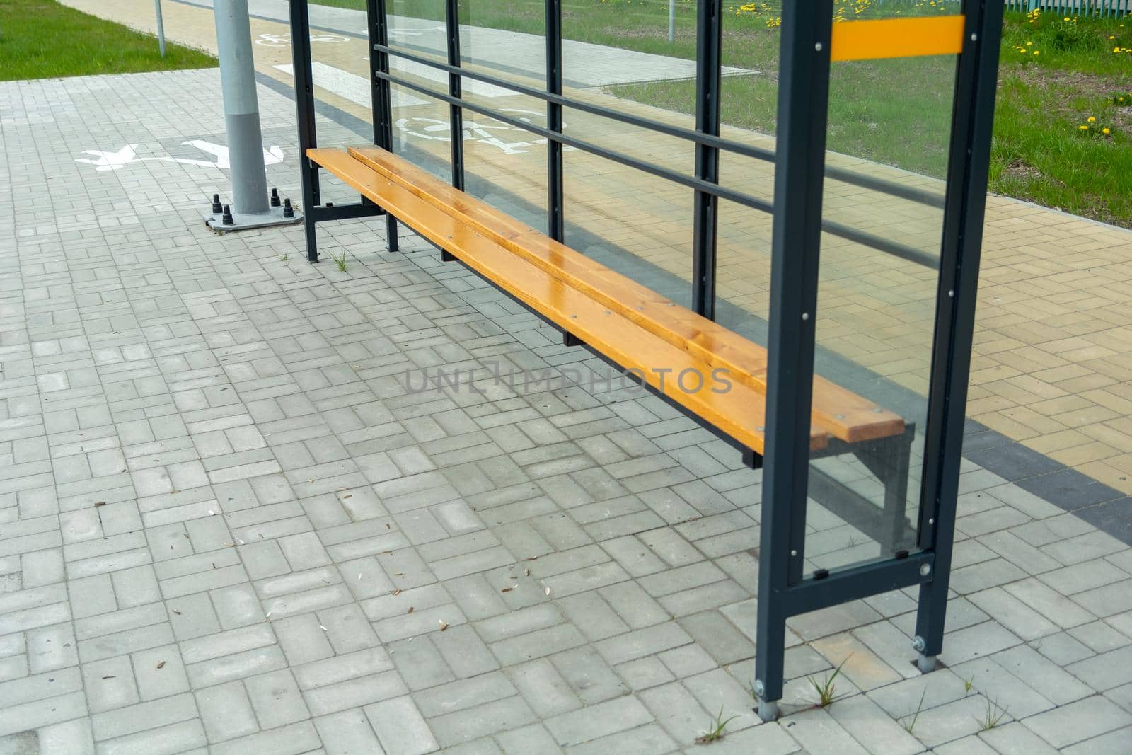 New glass shelter bus stop with wooden bench
