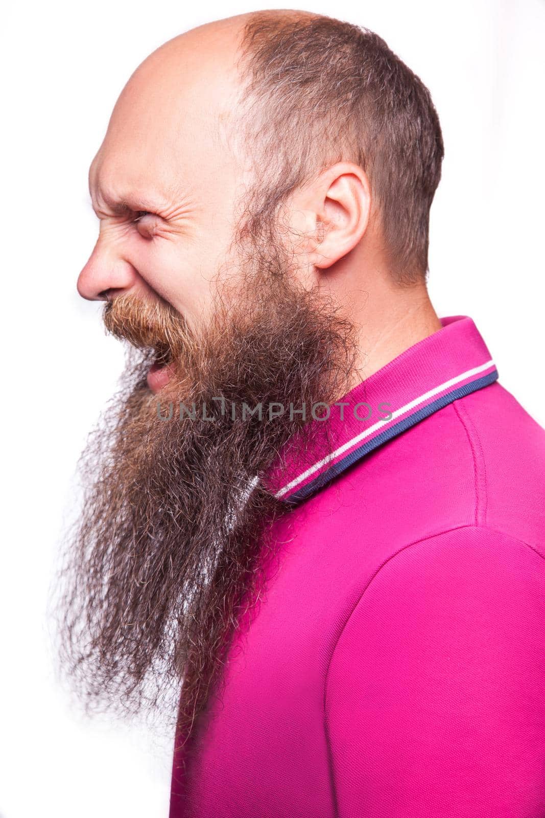 Unleashed emotions. Frustrated young man with blue opened eyes and mouth opened while standing looking at camera, isolated on white background.