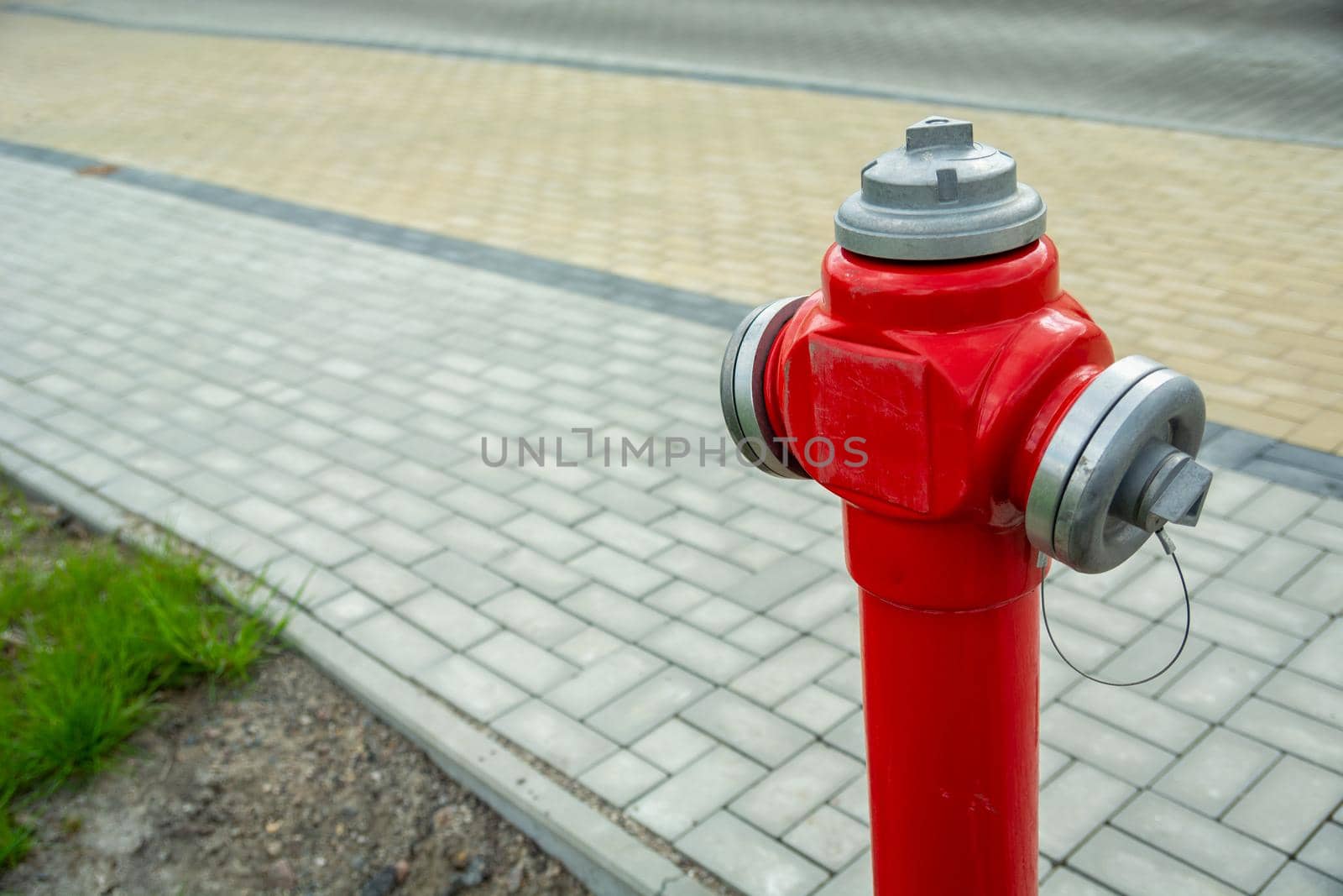New red fire hydrant standing by the town footpath