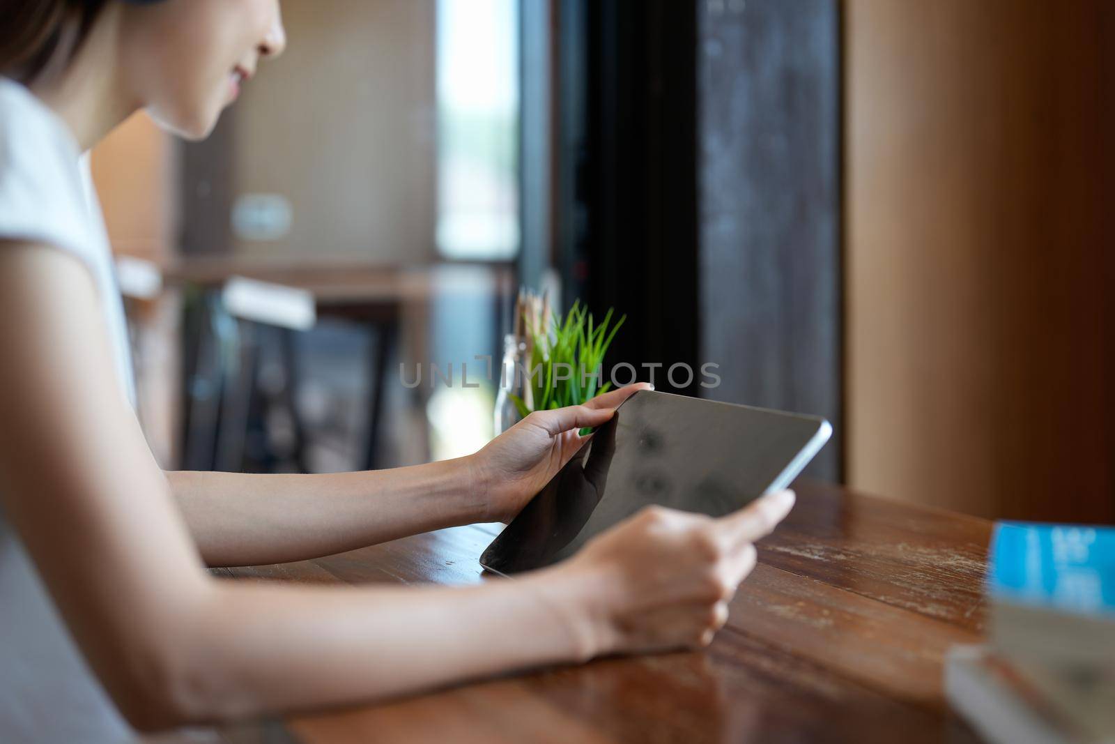 close up hands multitasking woman using tablet, laptop at cafe shop.
