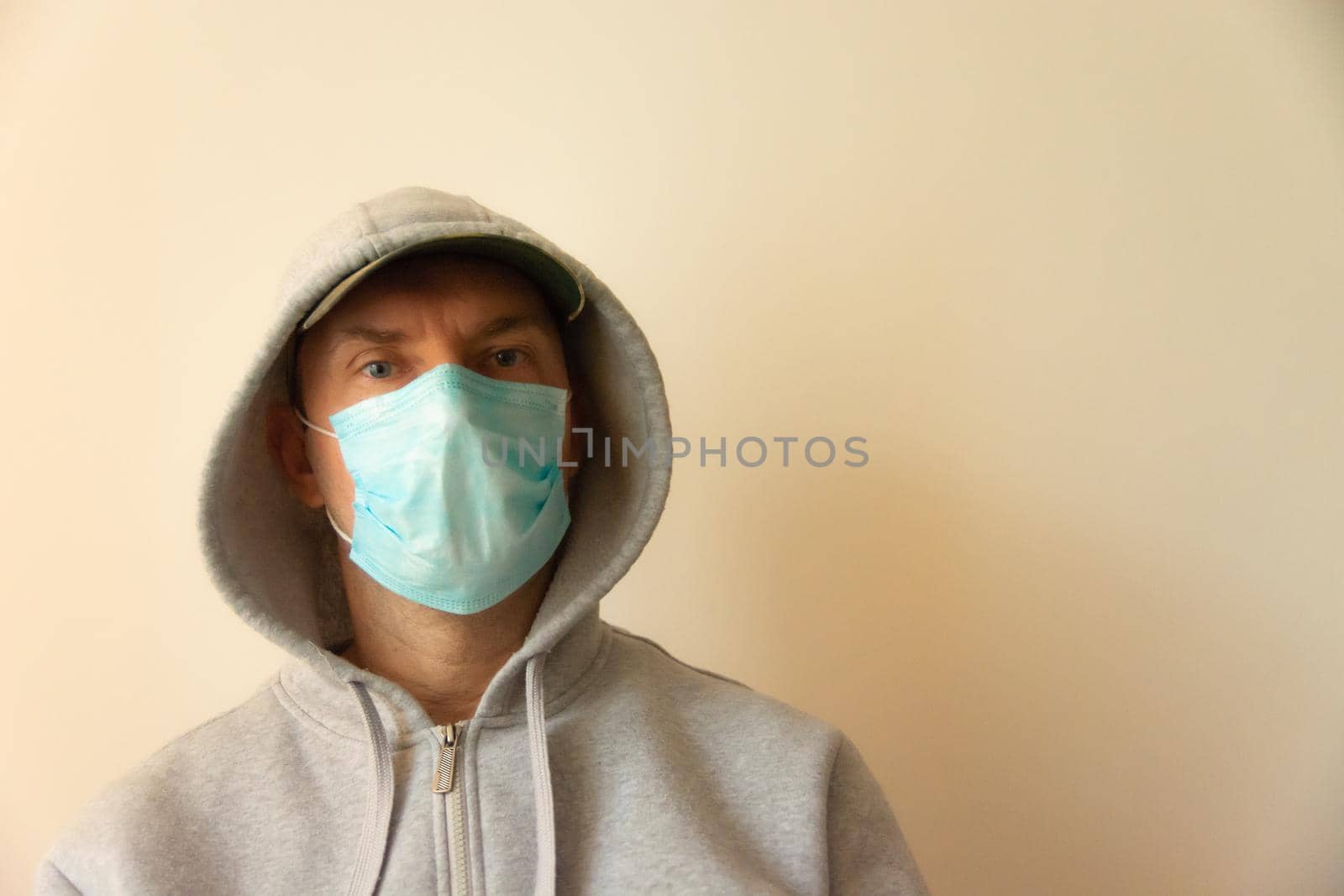 A man with a blue mask on his face and a hood on his head