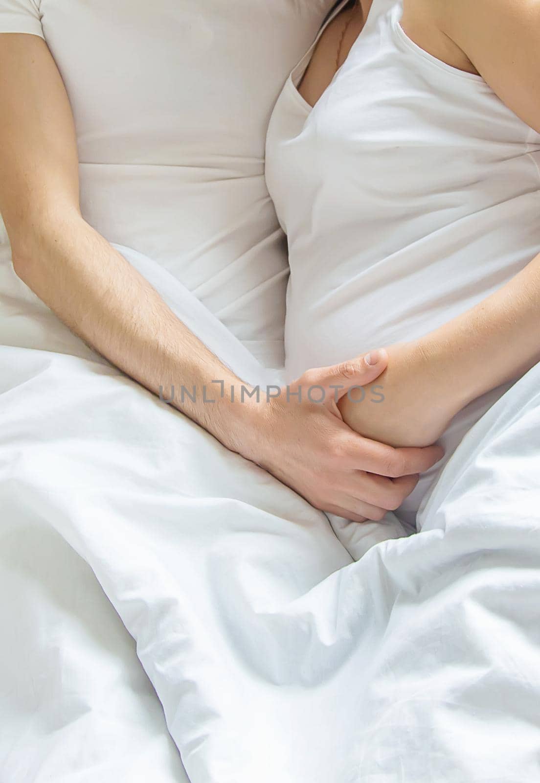 Pregnant woman with man hug belly in bed. Selective focus. people.