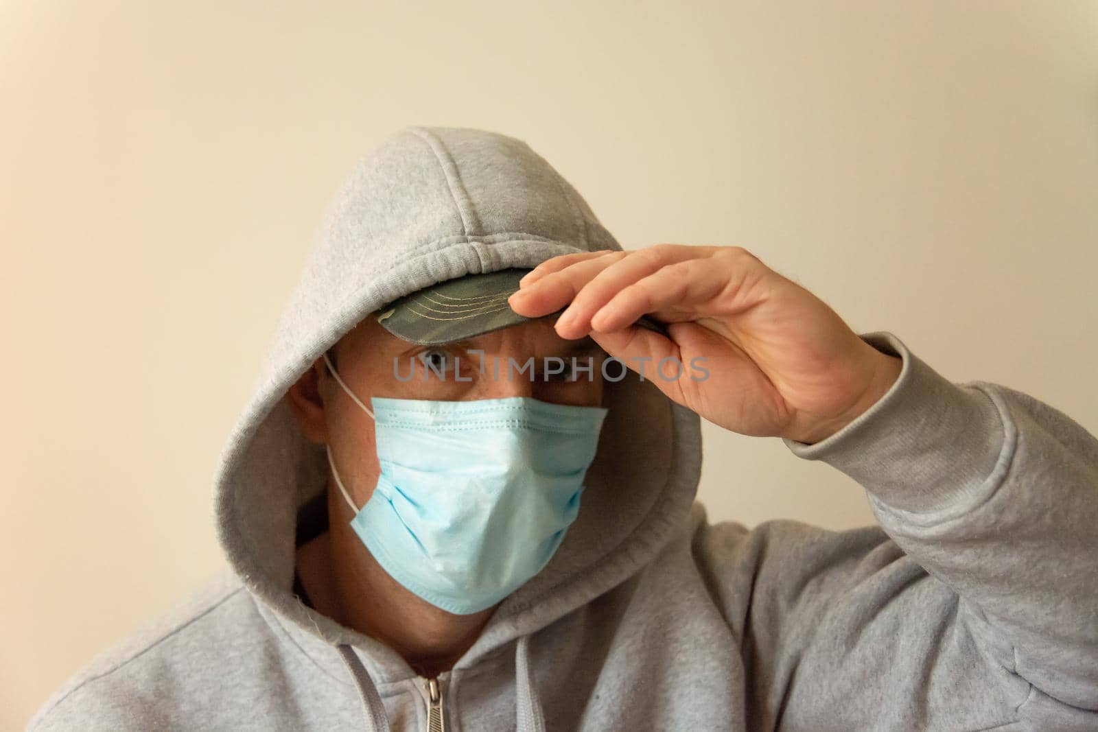 A man with a blue mask on his face and a hood on his head