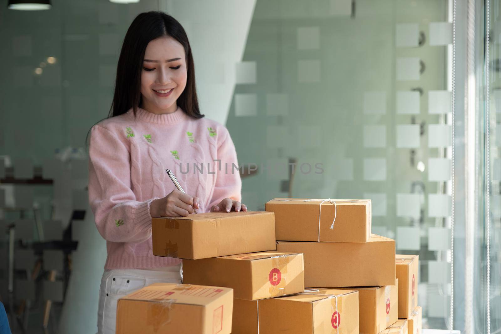 Close up hand of young woman small business owner online shopping at home preparing package product on background. SME entrepreneur or freelance life style concept. by nateemee