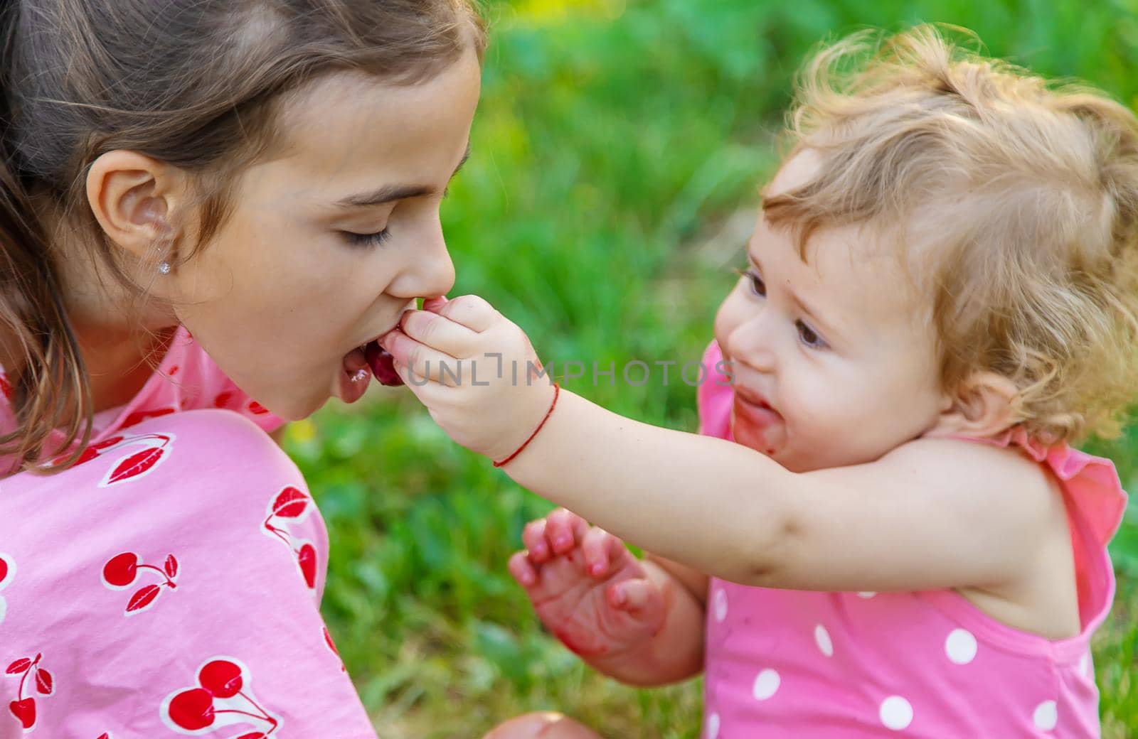 The child eats cherries in the garden. Selective focus. Food.