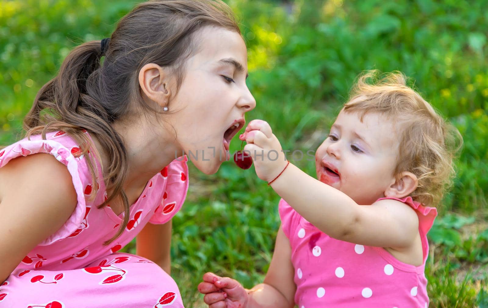 The child eats cherries in the garden. Selective focus. Food.