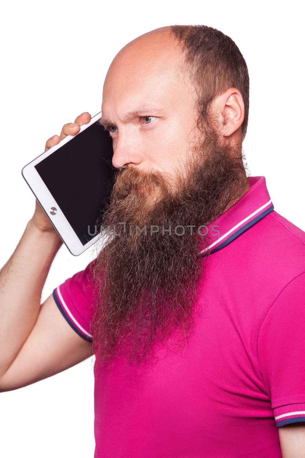 Portrait of bearded bald man holding and using digital tablet on white background