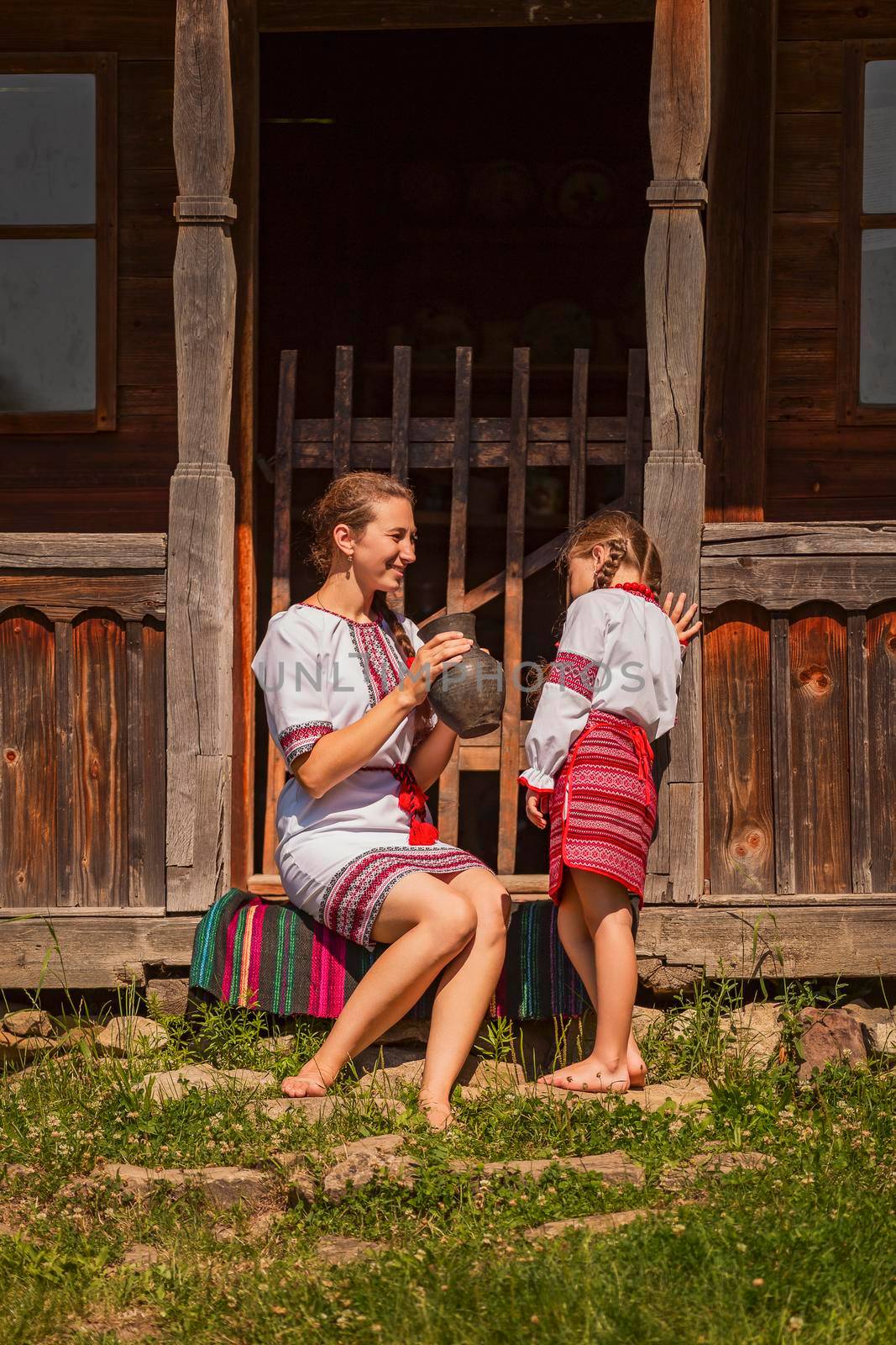 mother with daughter and a jug from which they drink milk