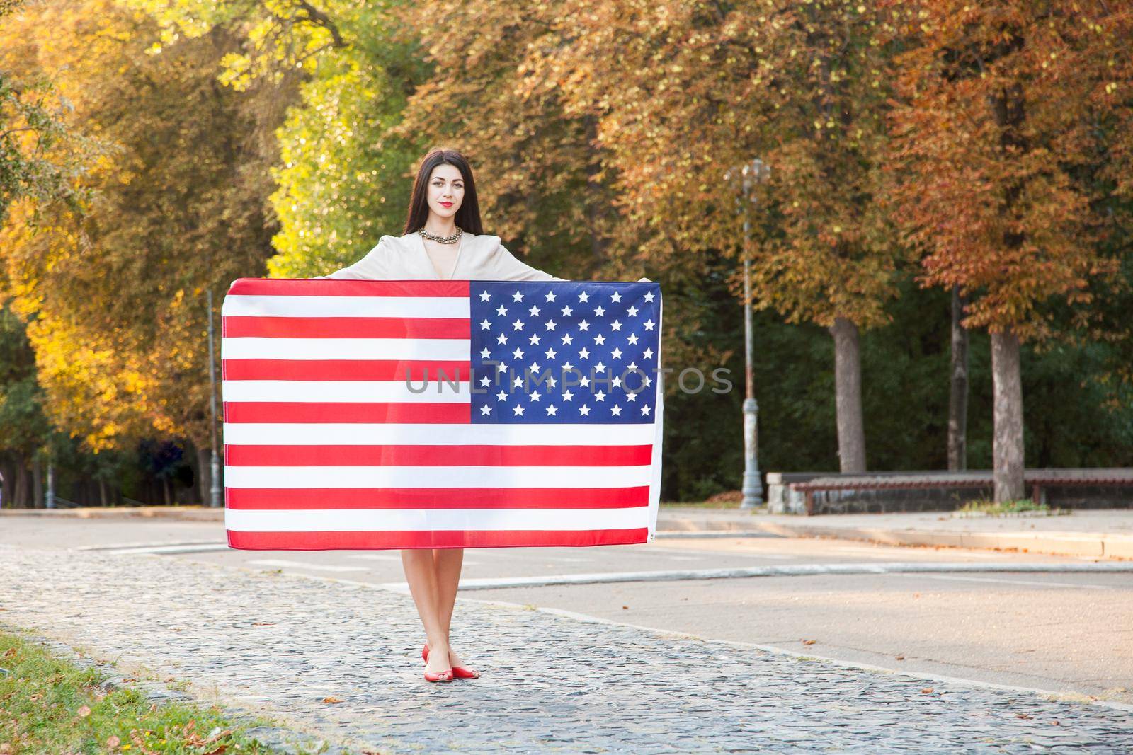 Beautiful happy woman with American flag celebrating independence day. by Khosro1