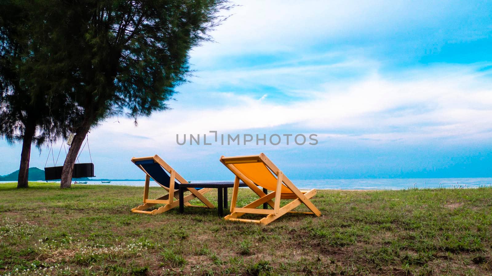 Empty Beautiful color deck chairs on the beach coat with blue sky background. Abstract vacation happy holiday