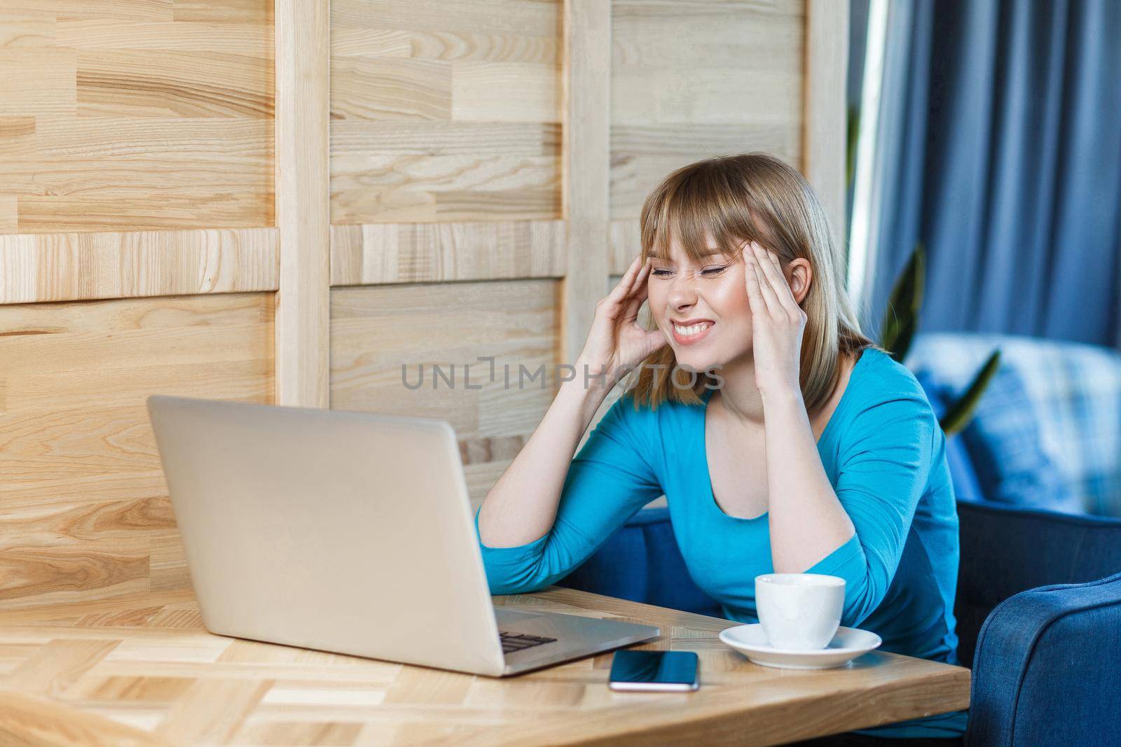 Be waiting an idea! Side view portrait of thoughtful attractive young girl freelancer in blue t-shirt are sitting in cafe and working on laptop, closed eyes and try to remember information. indoor