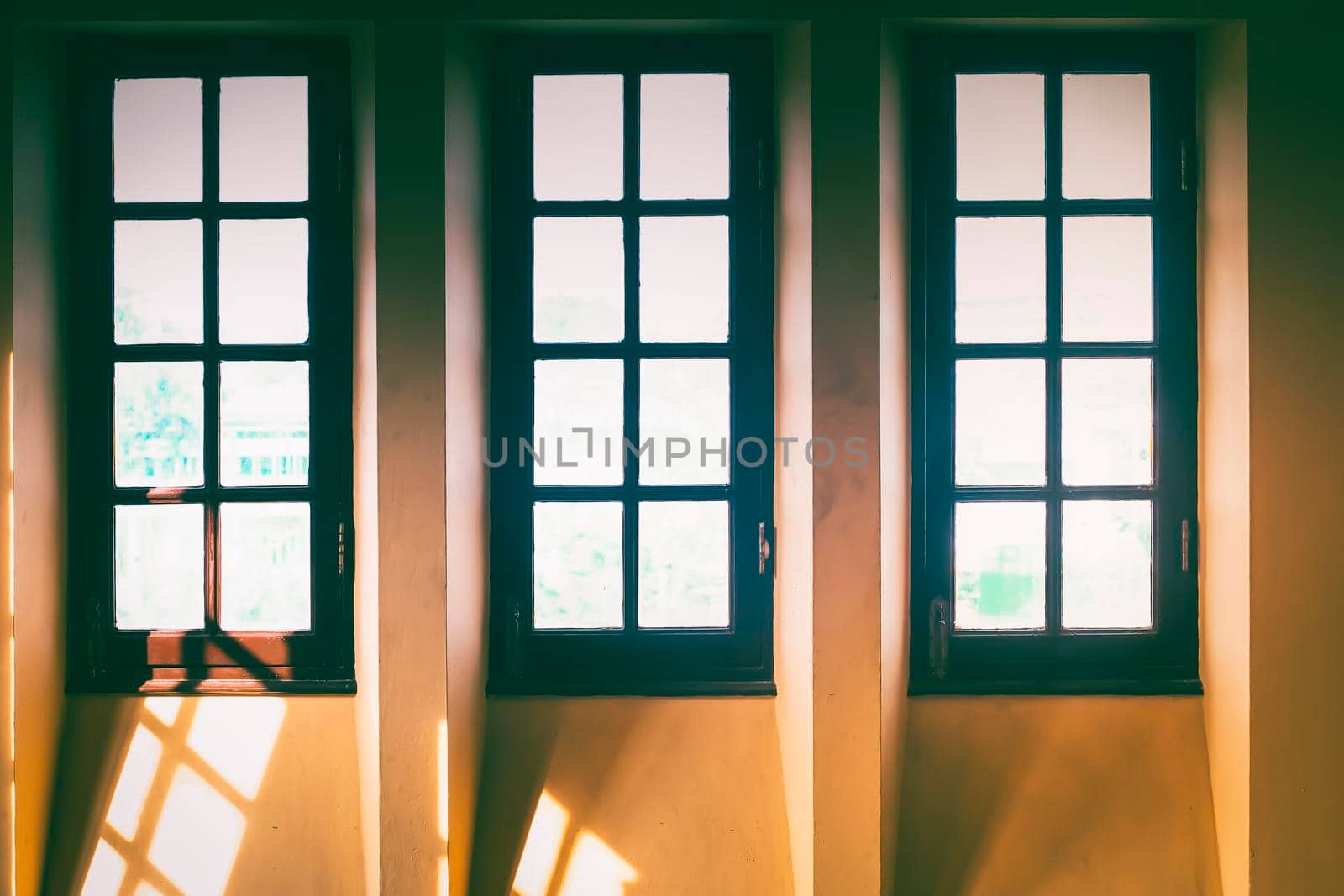 Old translucent glass with brown wooden frame window on white tone wall background by Petrichor