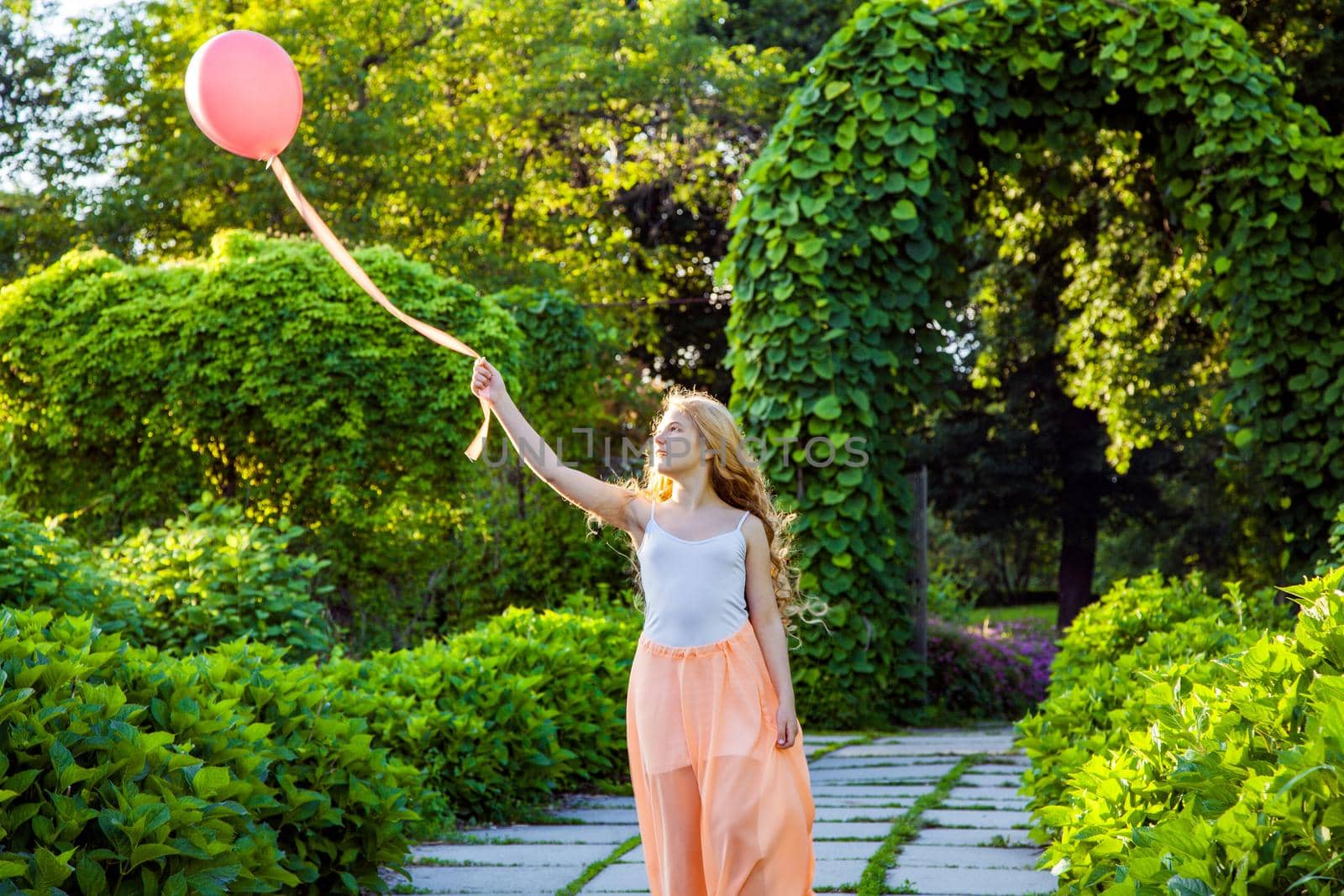 Portrait of happy girl with air balloon enjoying in the park on summertime.