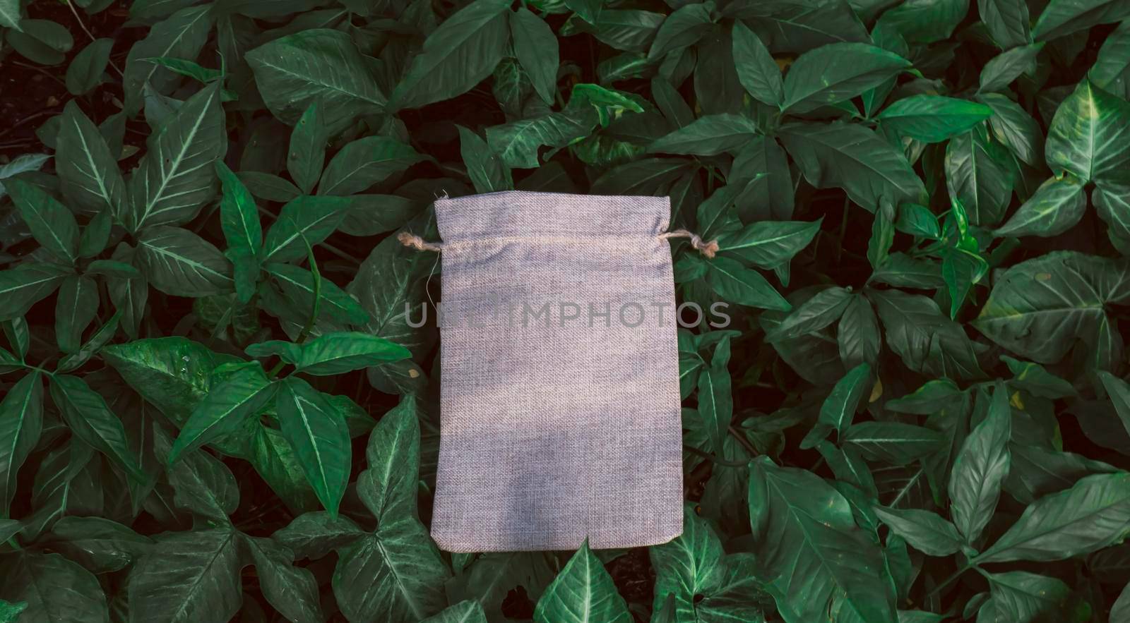Blank Mockup Linen Cotton Tote Bag on Green Bush Trees Foliage Background. Eco Nature Friendly Style. Environmental Conservation Recycling Concept. Template for Artwork Text