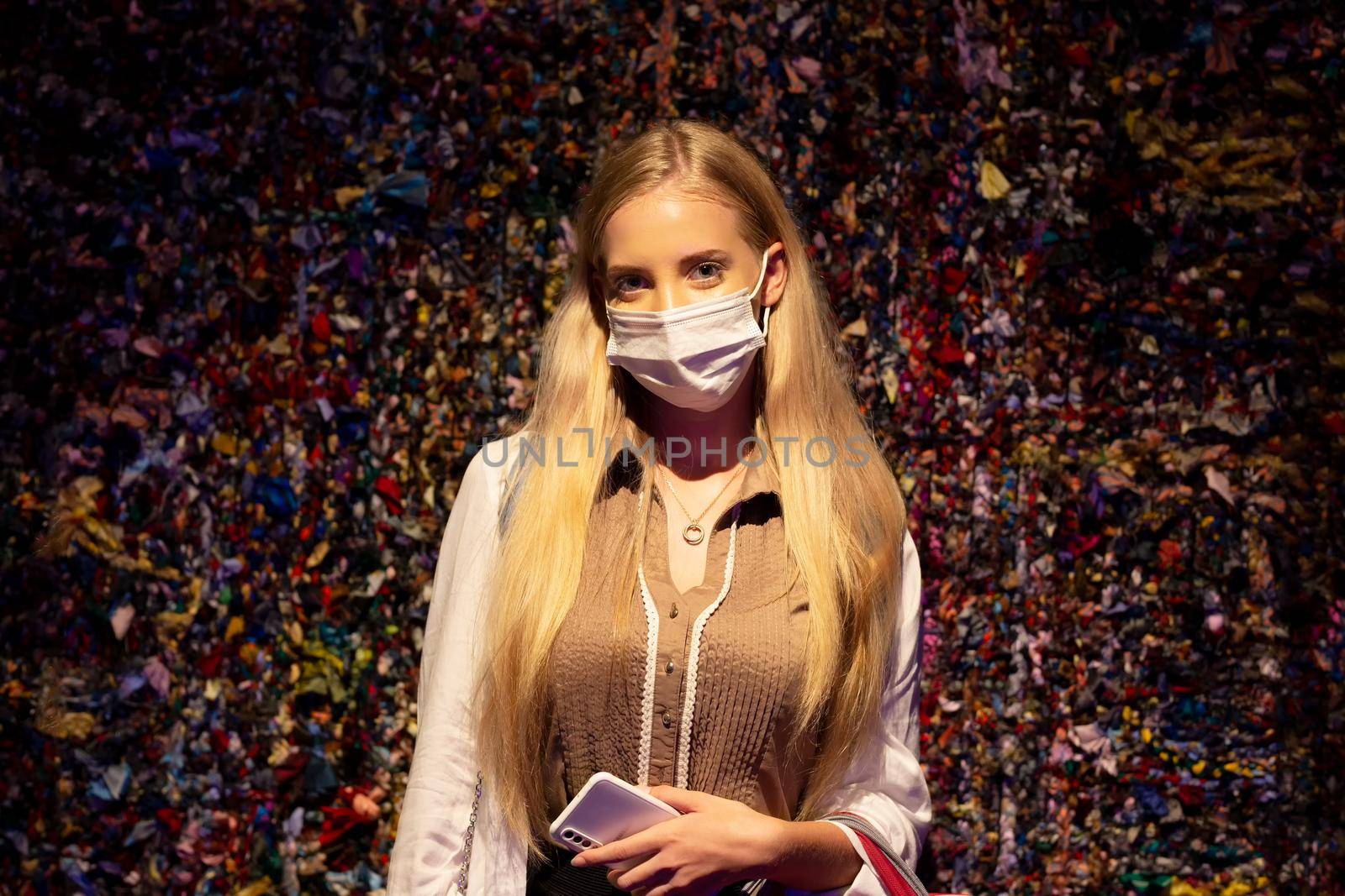 Portrait of smiling woman with mask against wall. by chuanchai