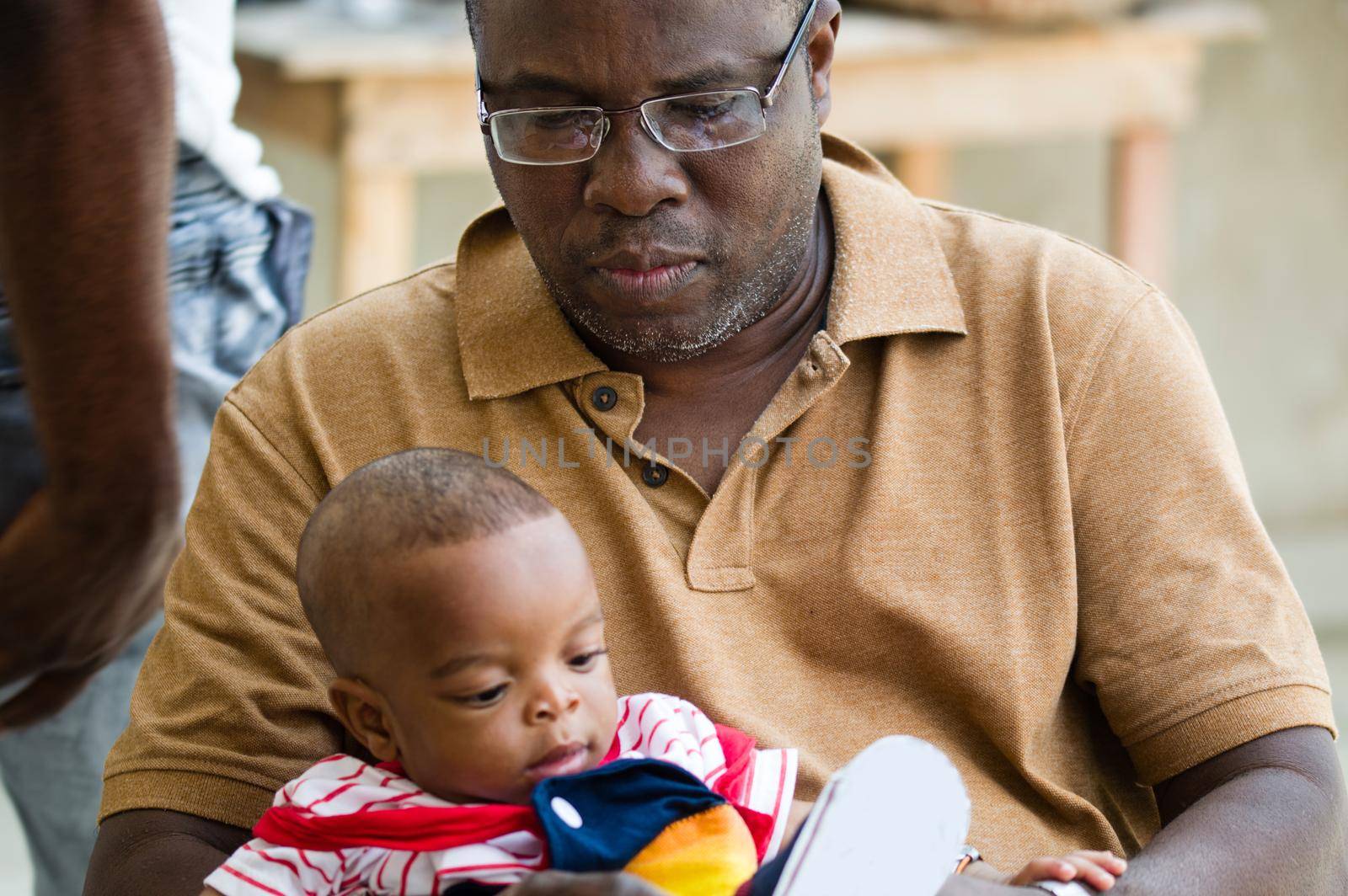 a man sitting outside holding his baby.