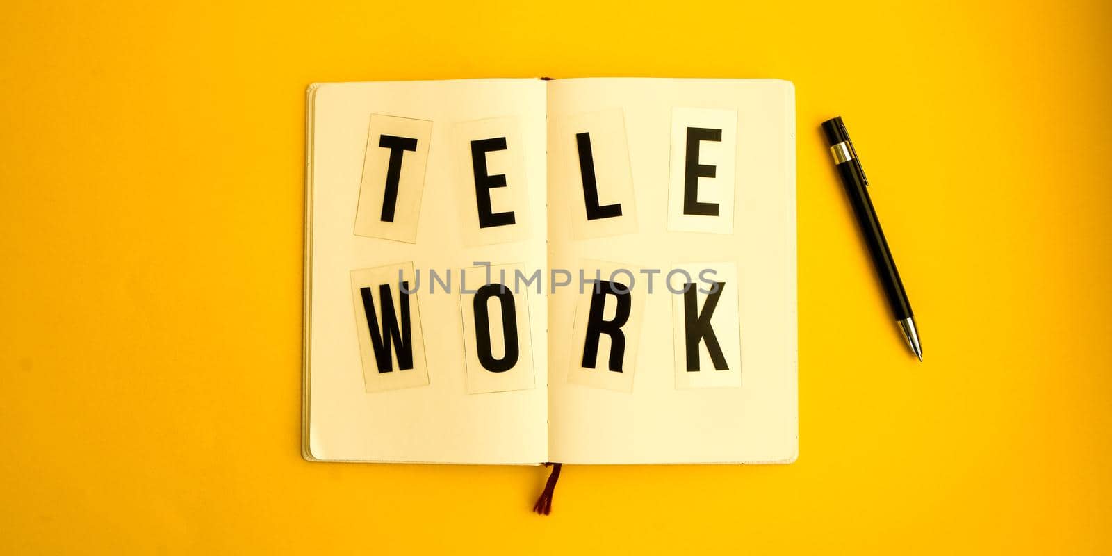 Text TELEWORK with notebook and pen, cactus, work from home place, freelance environment on yellow background copy space, planning day, to do list