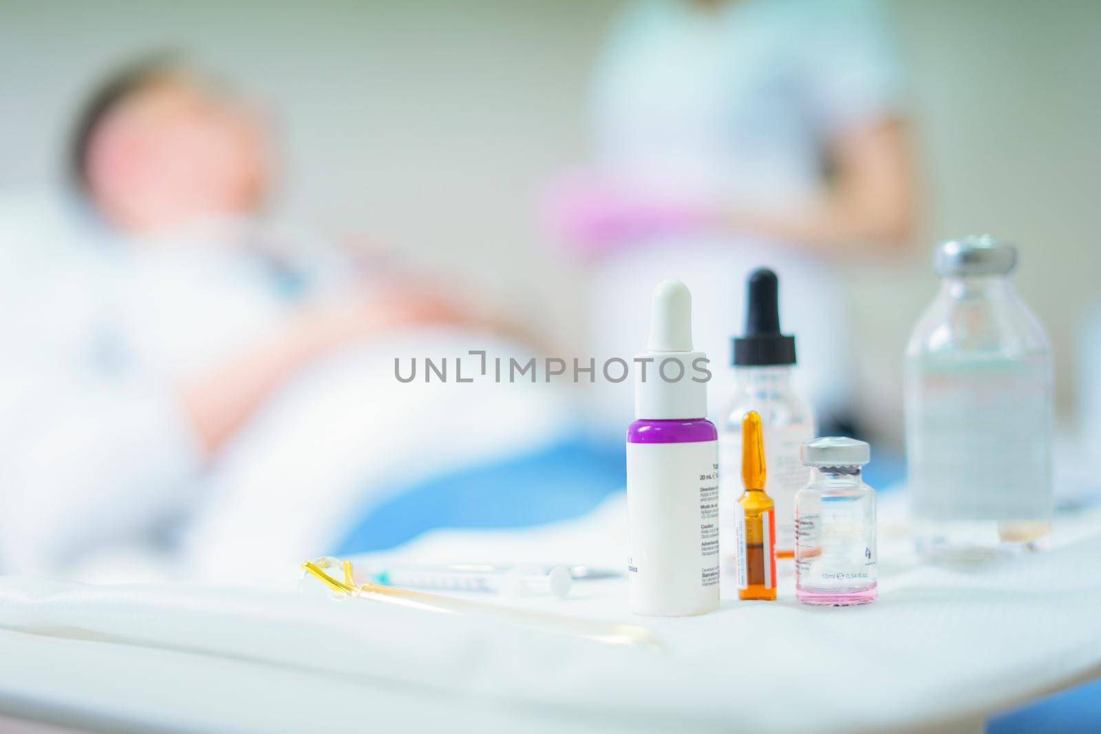 Medical ampules and some drugs with patient in hospital on blurred background