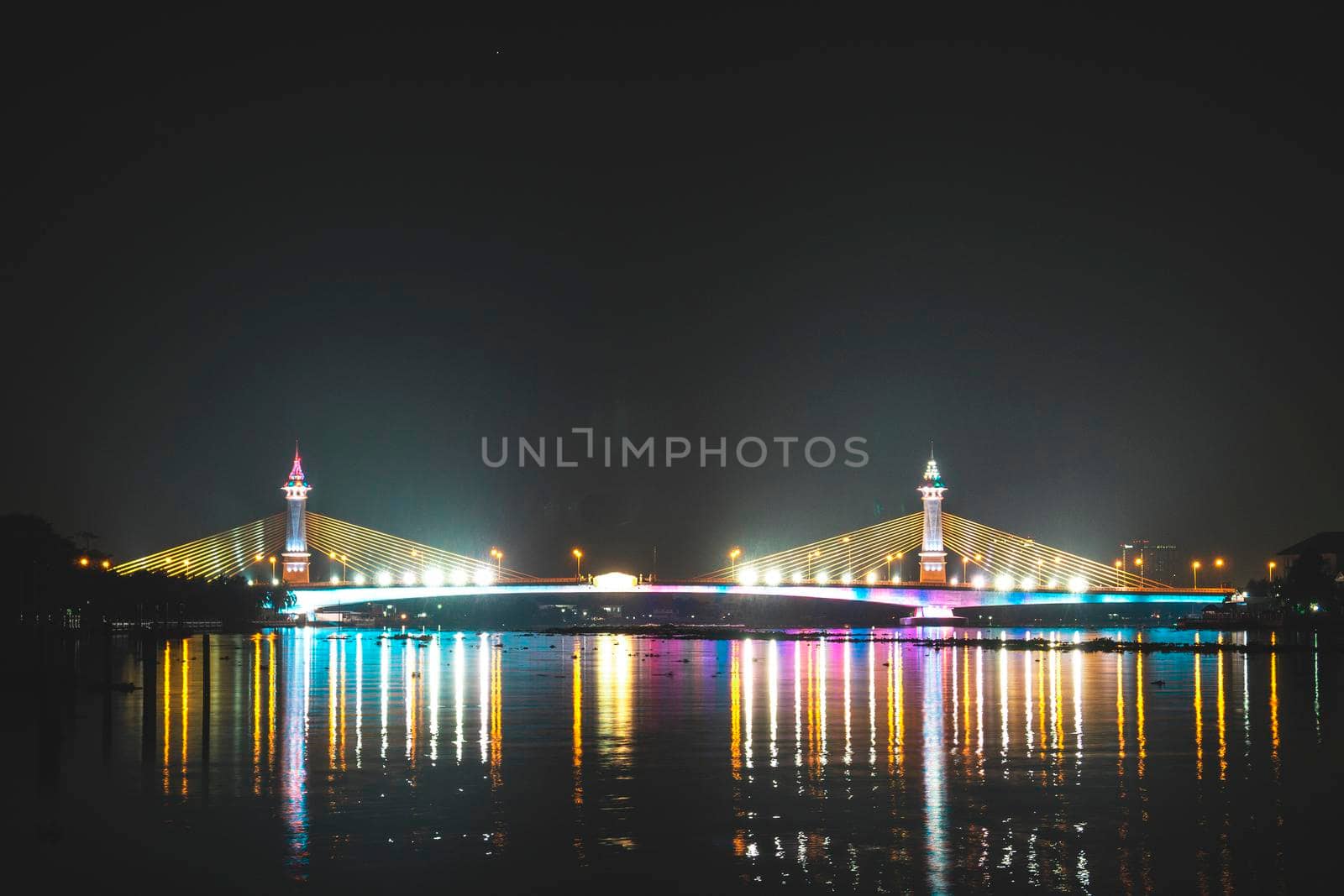 view of night scenery of city in Thailand  with beautiful reflections of skyscrapers and bridges by riverside in twilight. Cityscape view of bridge crosses the Chao Phraya River