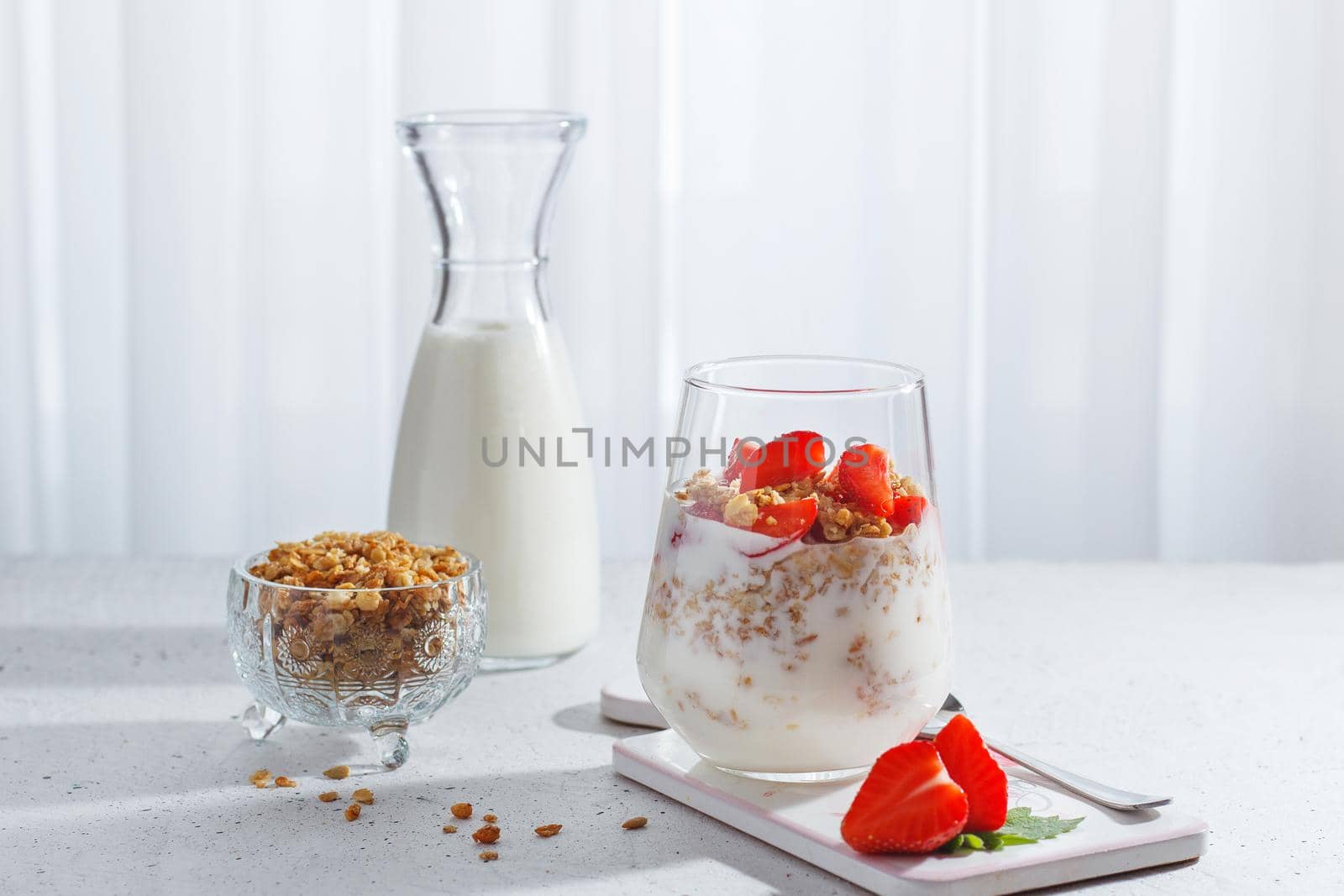 A glass of healthy yogurt with fresh berries and granola on a gray background.Healthy breakfast.