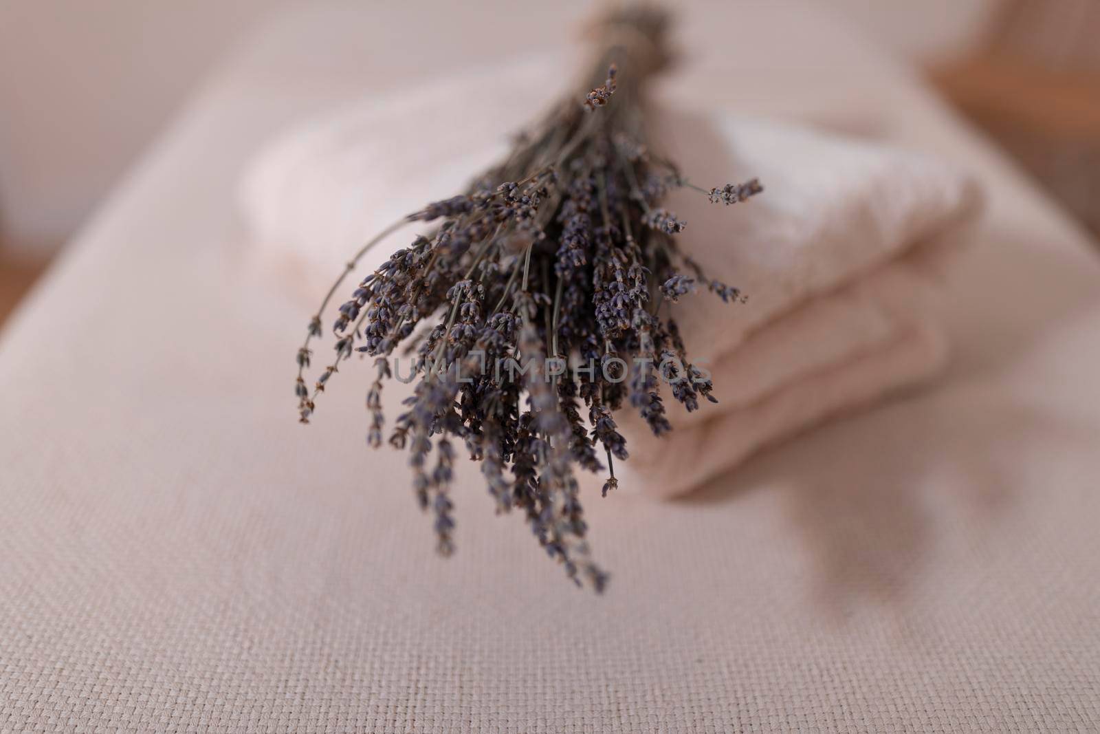 Close-up of a bunch of aromatic lavender flowers lying over some towels in a massage room