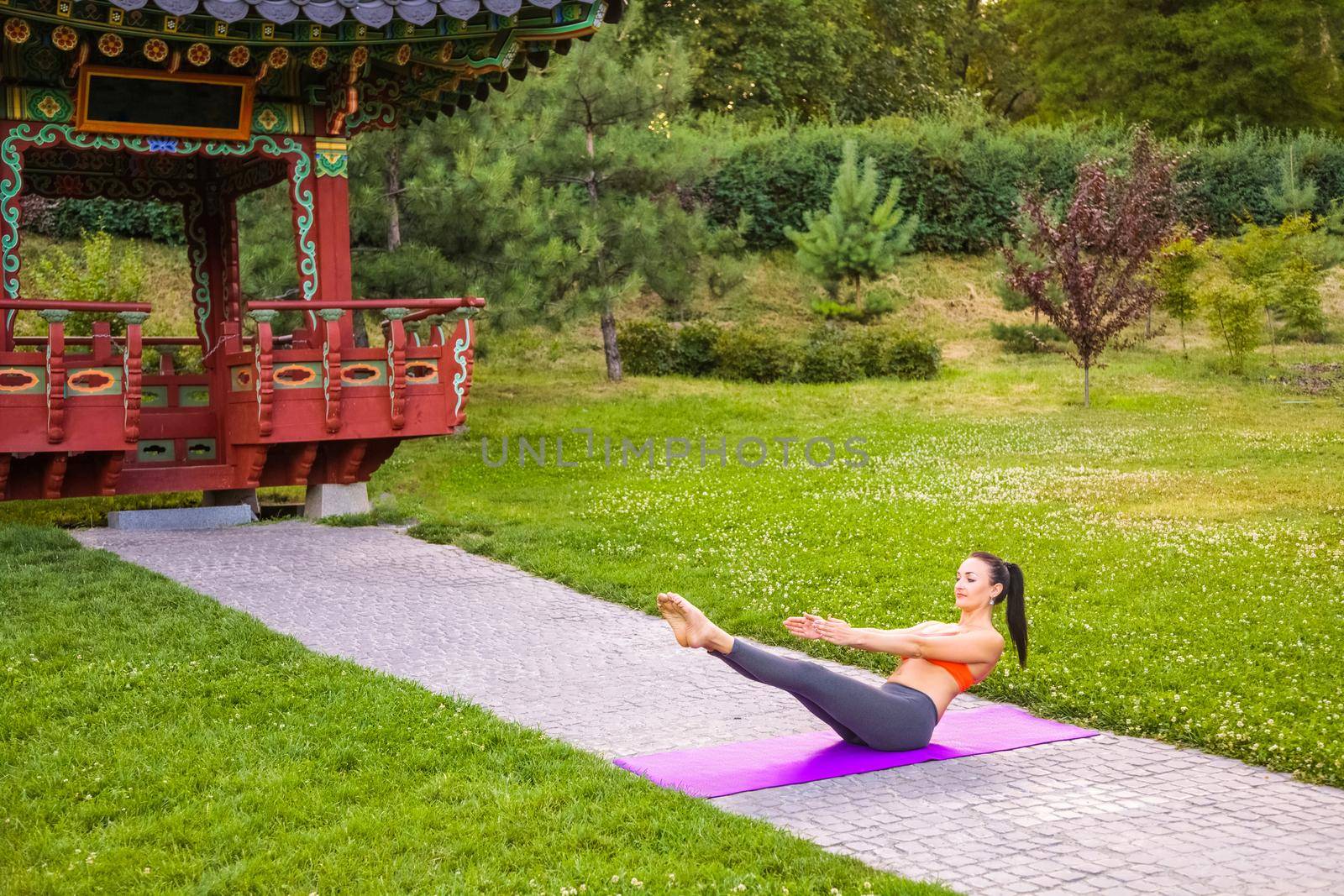 Young woman practicing yoga in the park. by Khosro1
