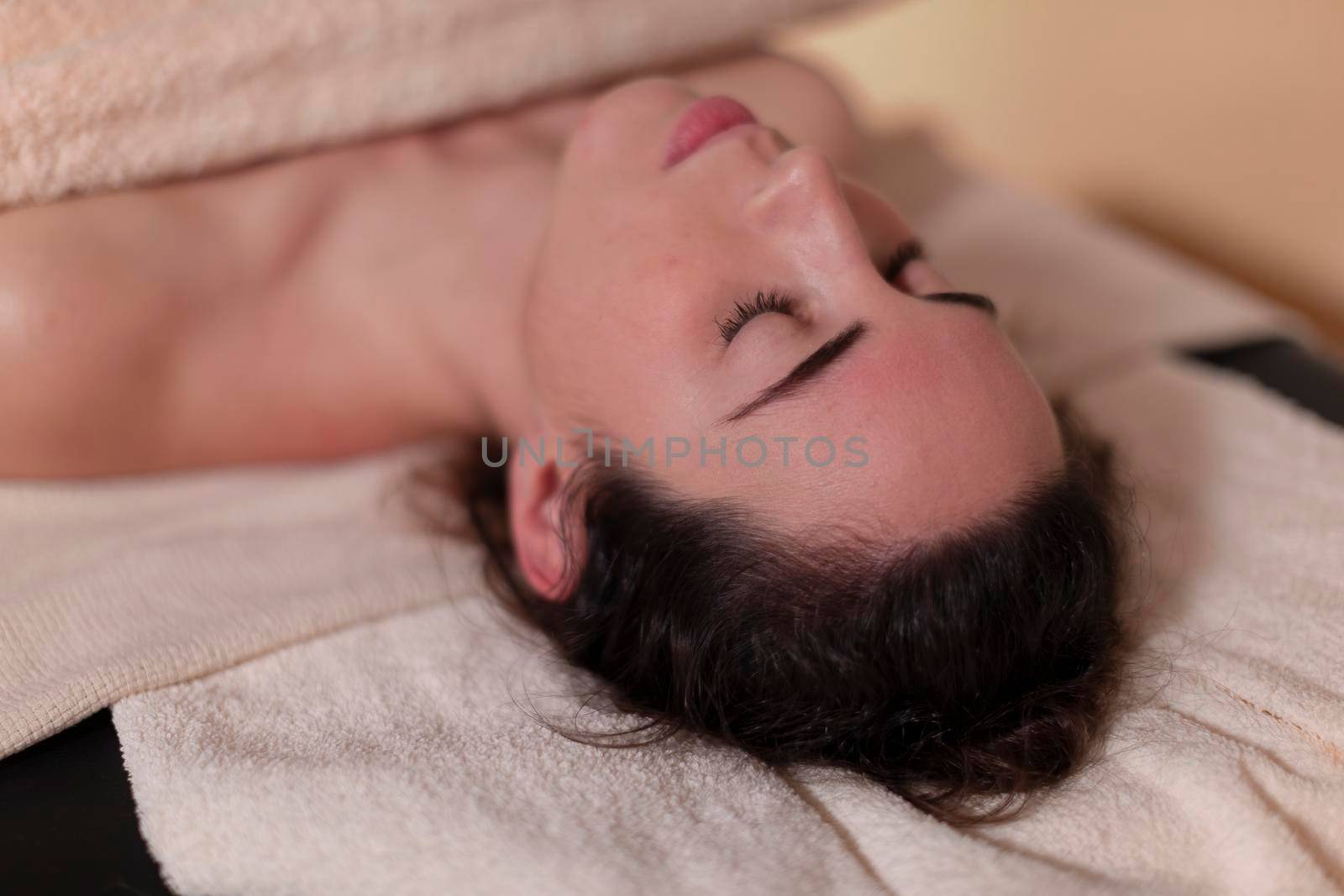A patient lies relaxed on the massage table by stockrojoverdeyazul