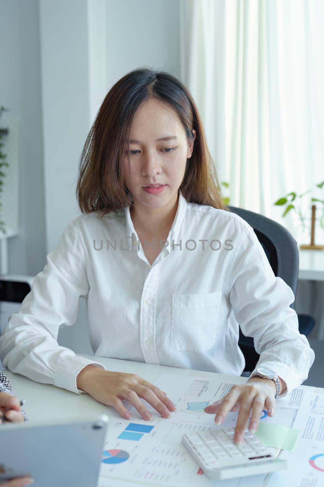 accountant, Auditor, Self-Employed, Finance and Investment, tax calculation and budget, Asian female entrepreneur using a calculator to calculate. Company business results document. by Manastrong