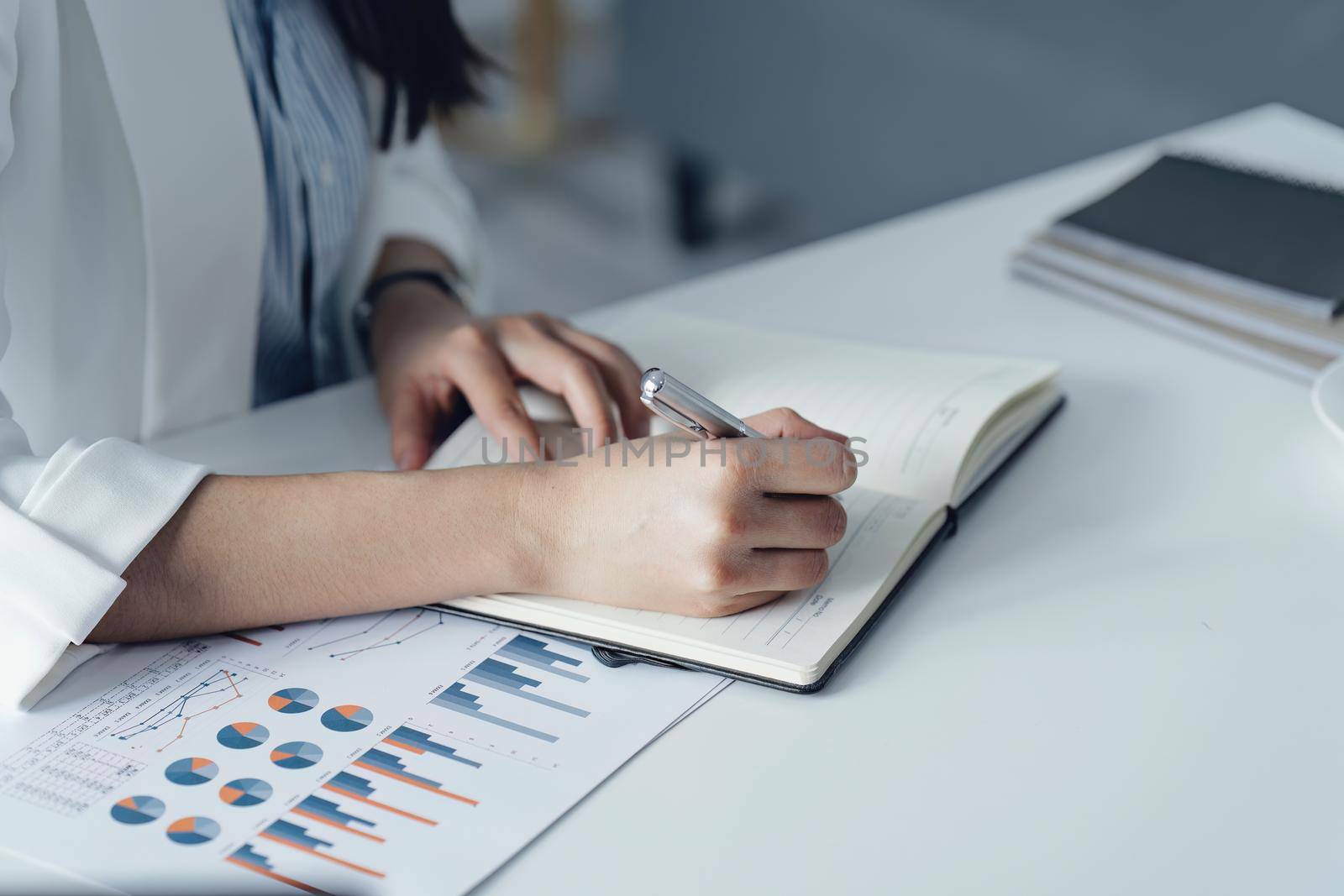 Portrait of a young businesswoman or business owner working with a notebook and documents at office room.