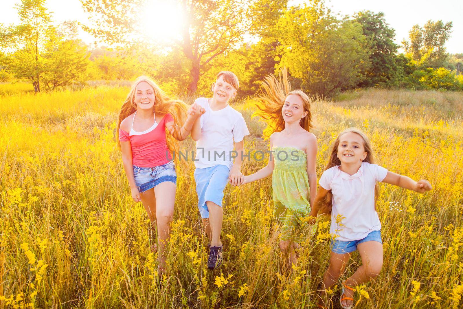 four happy beautiful children running playing moving together in the beautiful summer day. by Khosro1