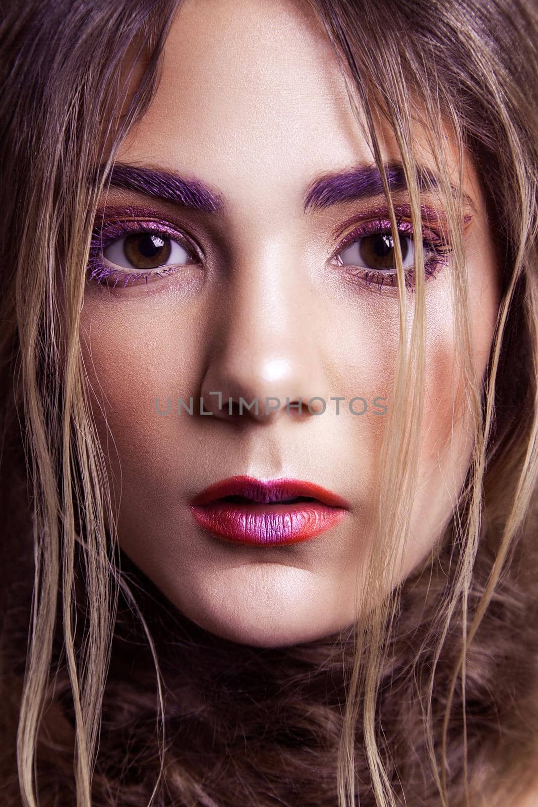 Closeup of beautiful fashion model with makeup and hairstyle on her face. Studio shot, looking at camera..retouched with special care and attention.
