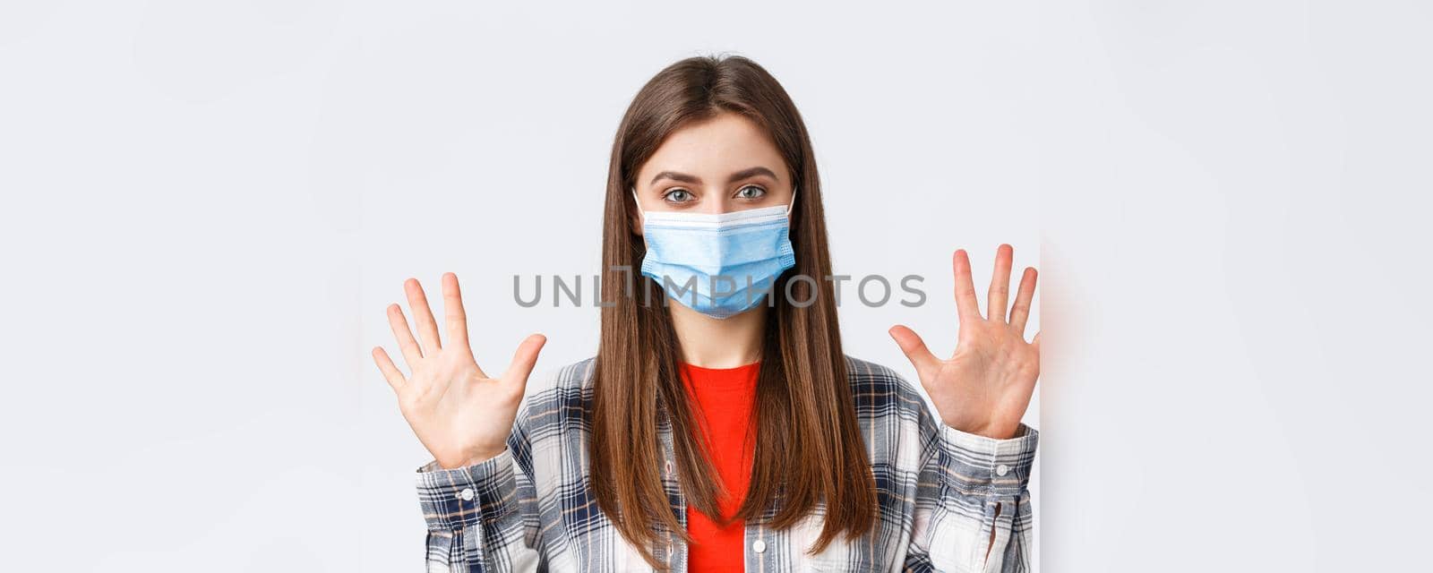 Coronavirus outbreak, leisure on quarantine, social distancing and emotions concept. Attractive caucasian woman in medical mask show ten fingers, amount or quantity, white background.